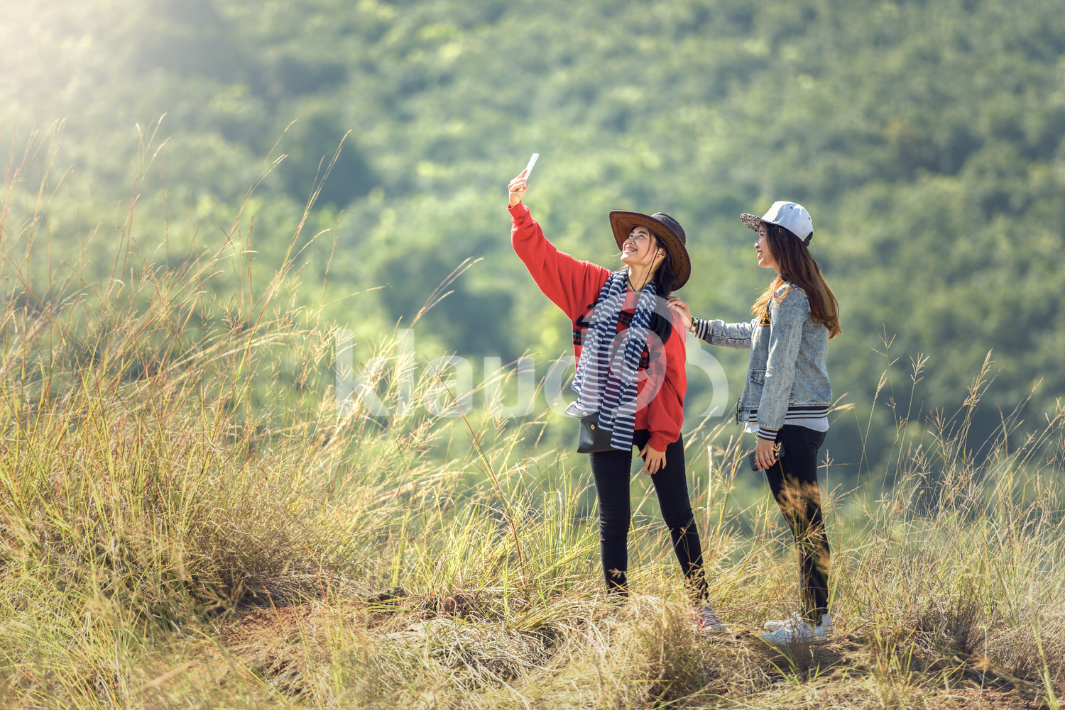 Woman taking selfies with smartphone at mountain peak