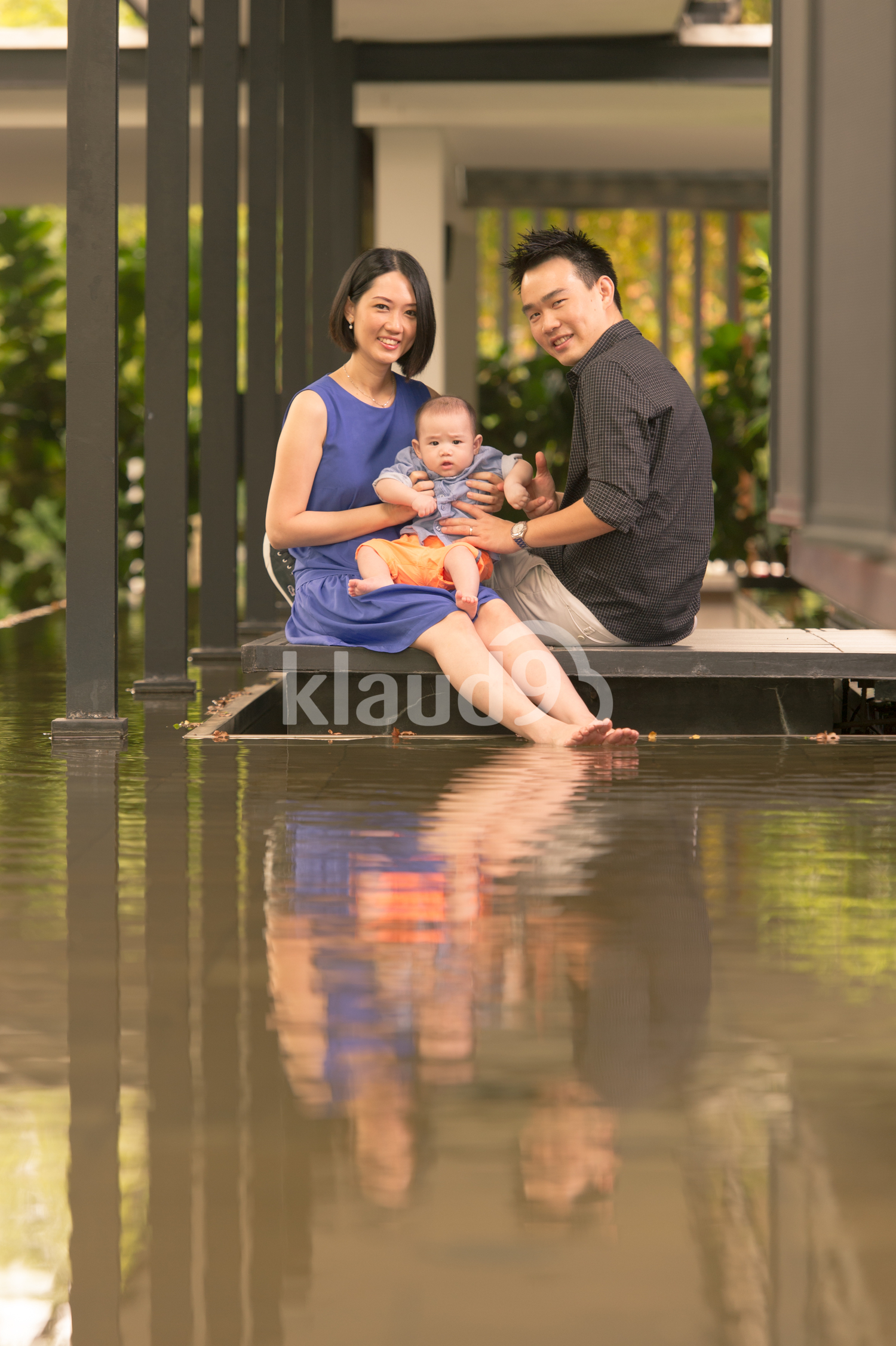 Young Chinese family with 5 month old son looking into camera