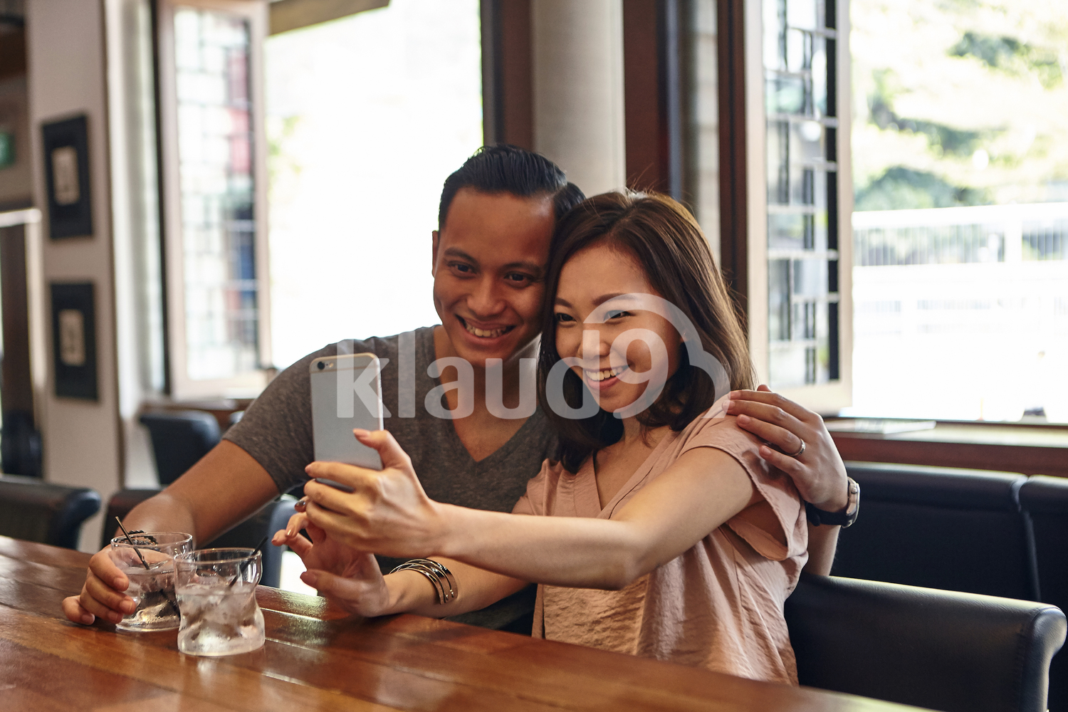 Happy couple taking selfies in a bar