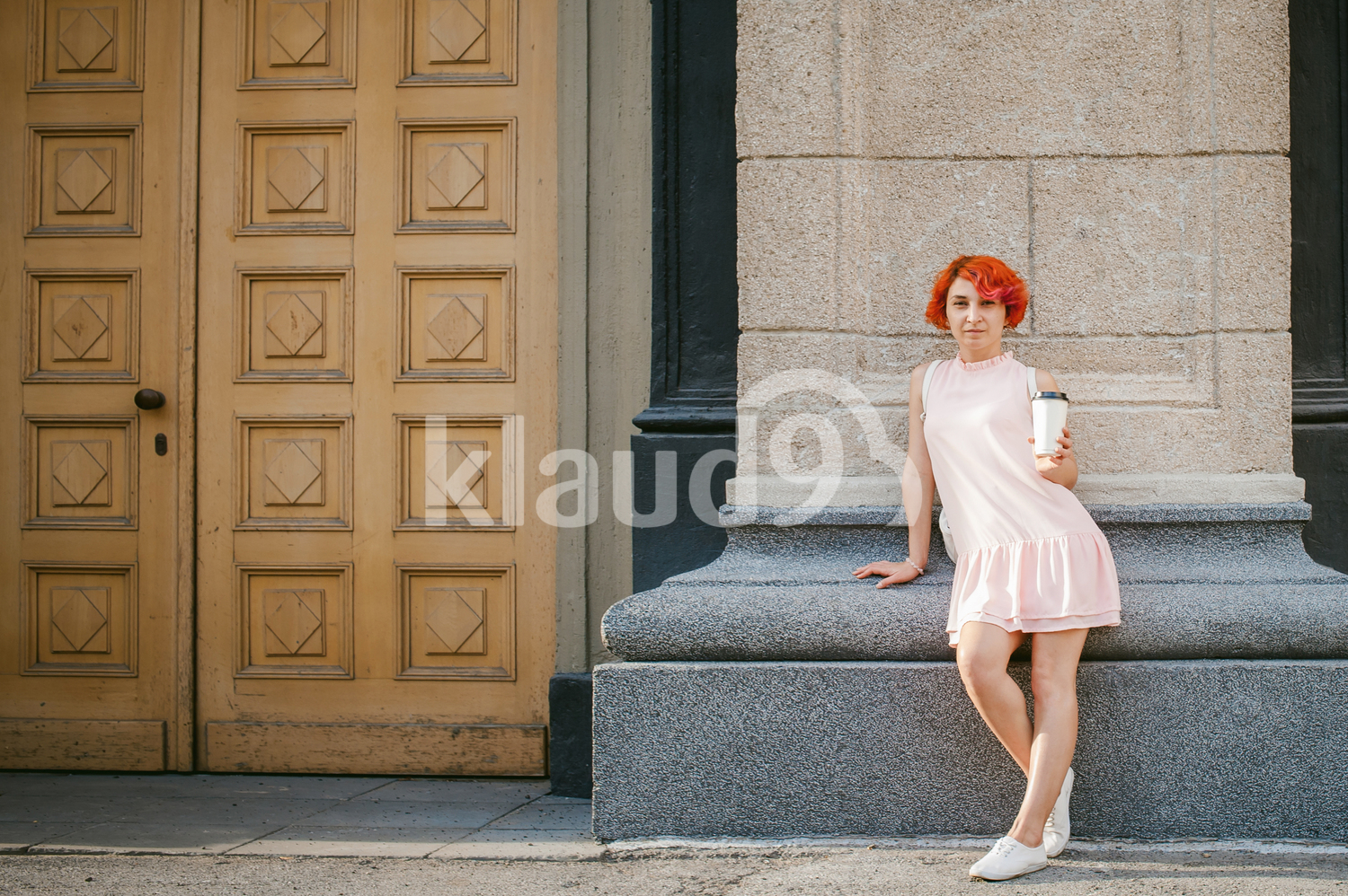 Portrait of a red haired lady drinking coffee
