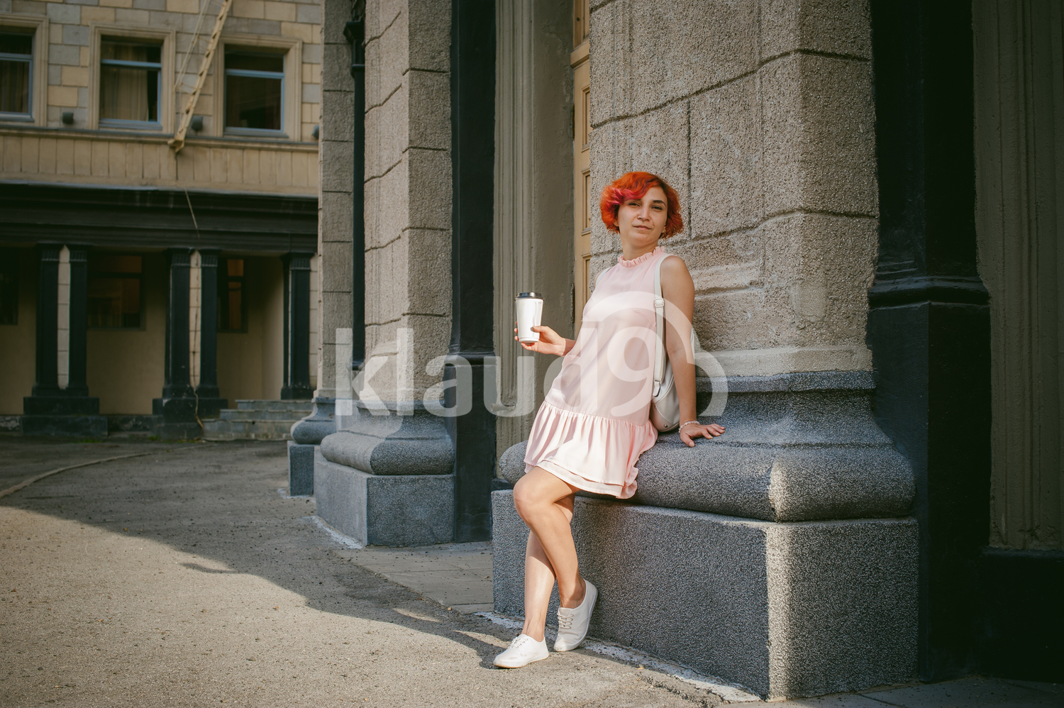Portrait of a red haired lady sipping on coffee