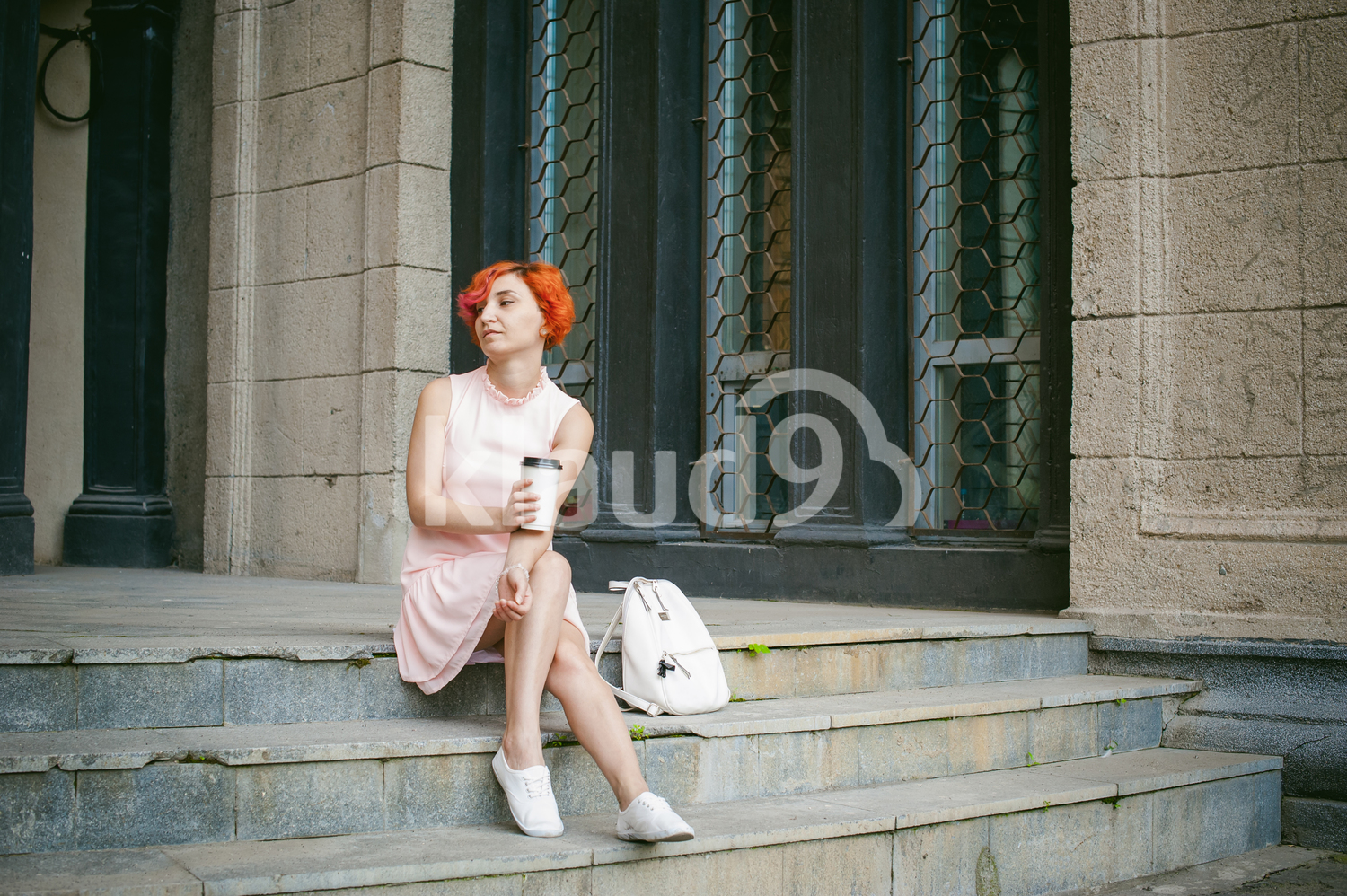 Red haired lady looking lost in her thoughts with a coffee cup