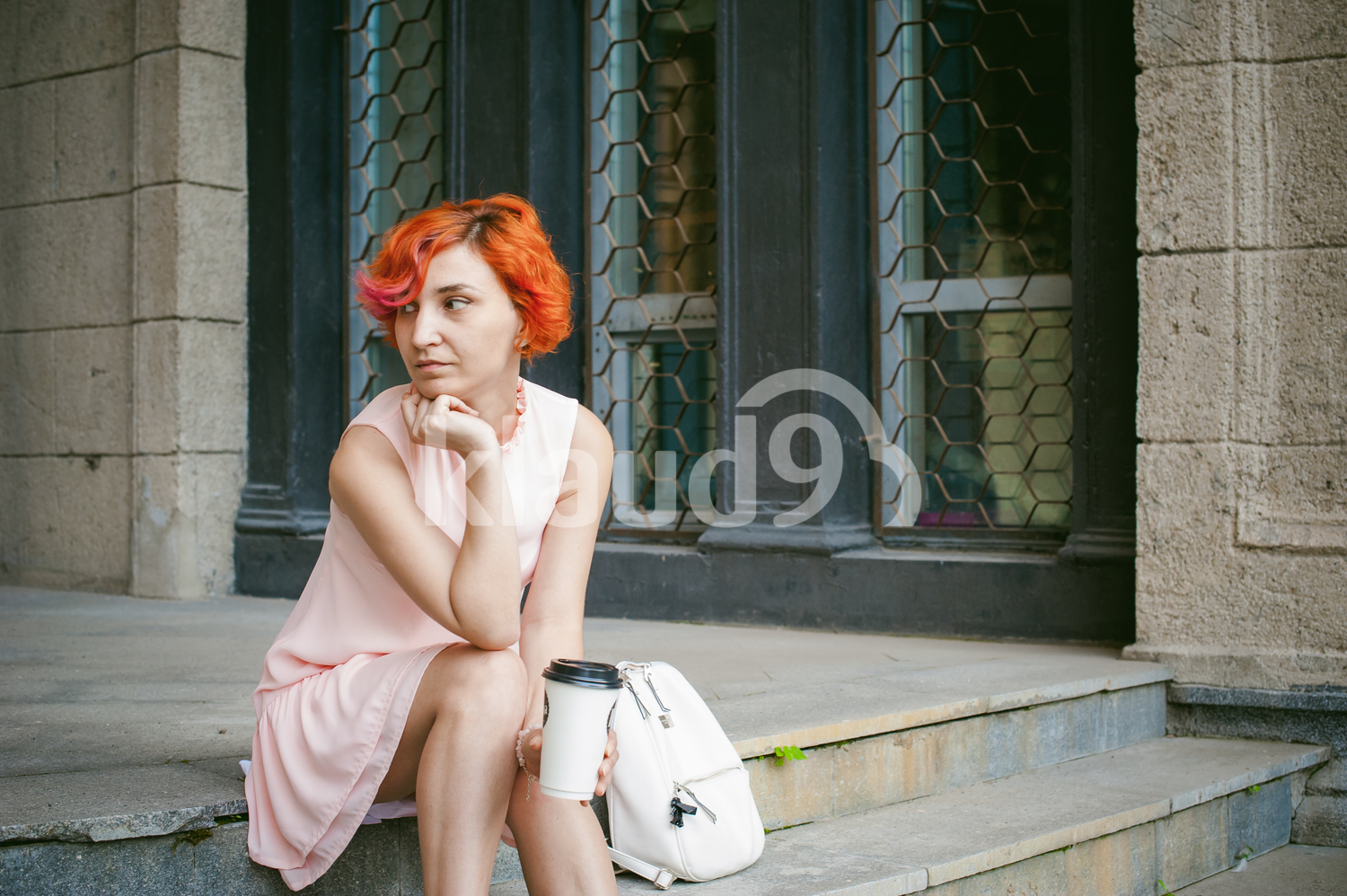 Woman with dyed red hair in a pale pink dress