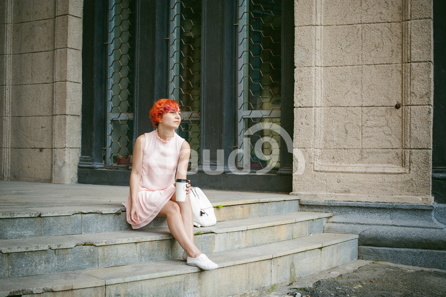Lady with red hair holding a coffee cup