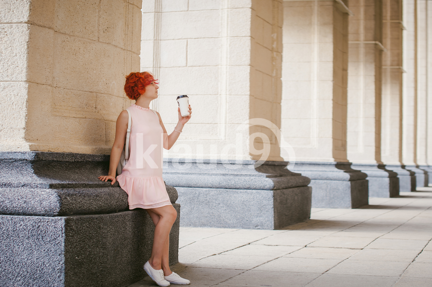 Woman in pale pink dress and a coffee cup