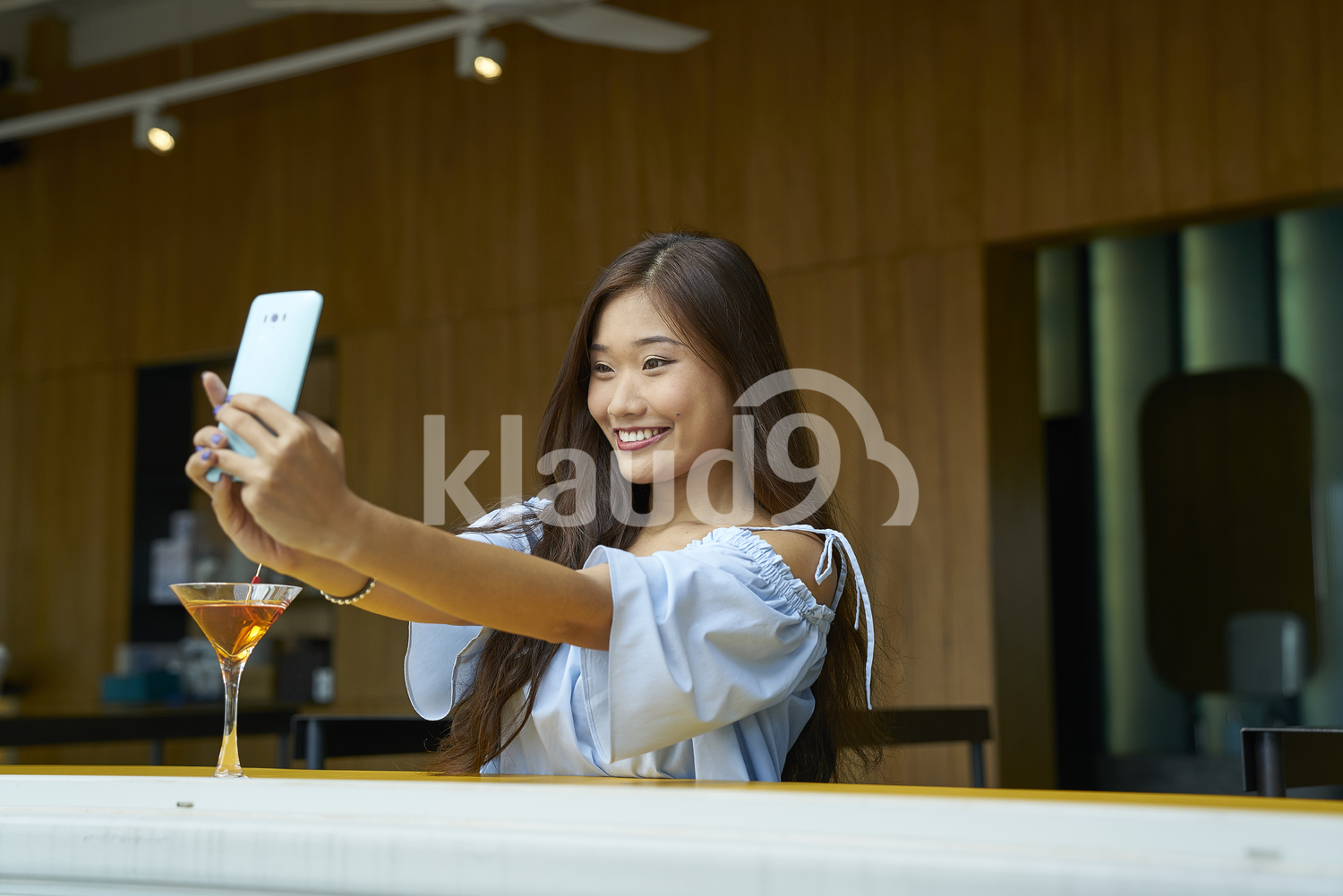 Woman taking a selfie in a bar