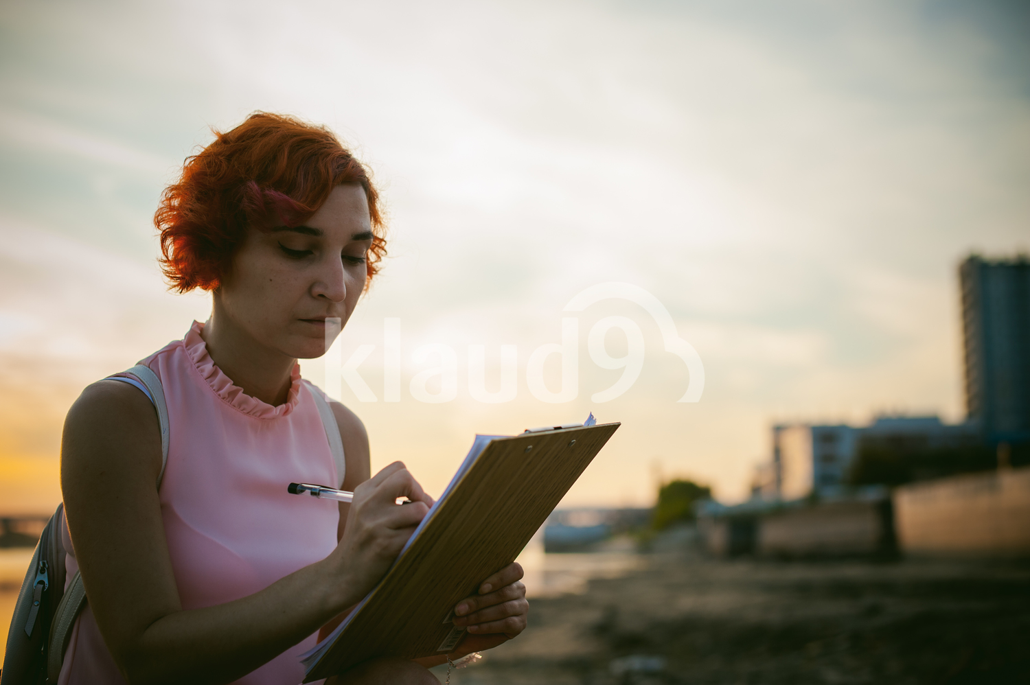 Woman with dyed red hair signing documents