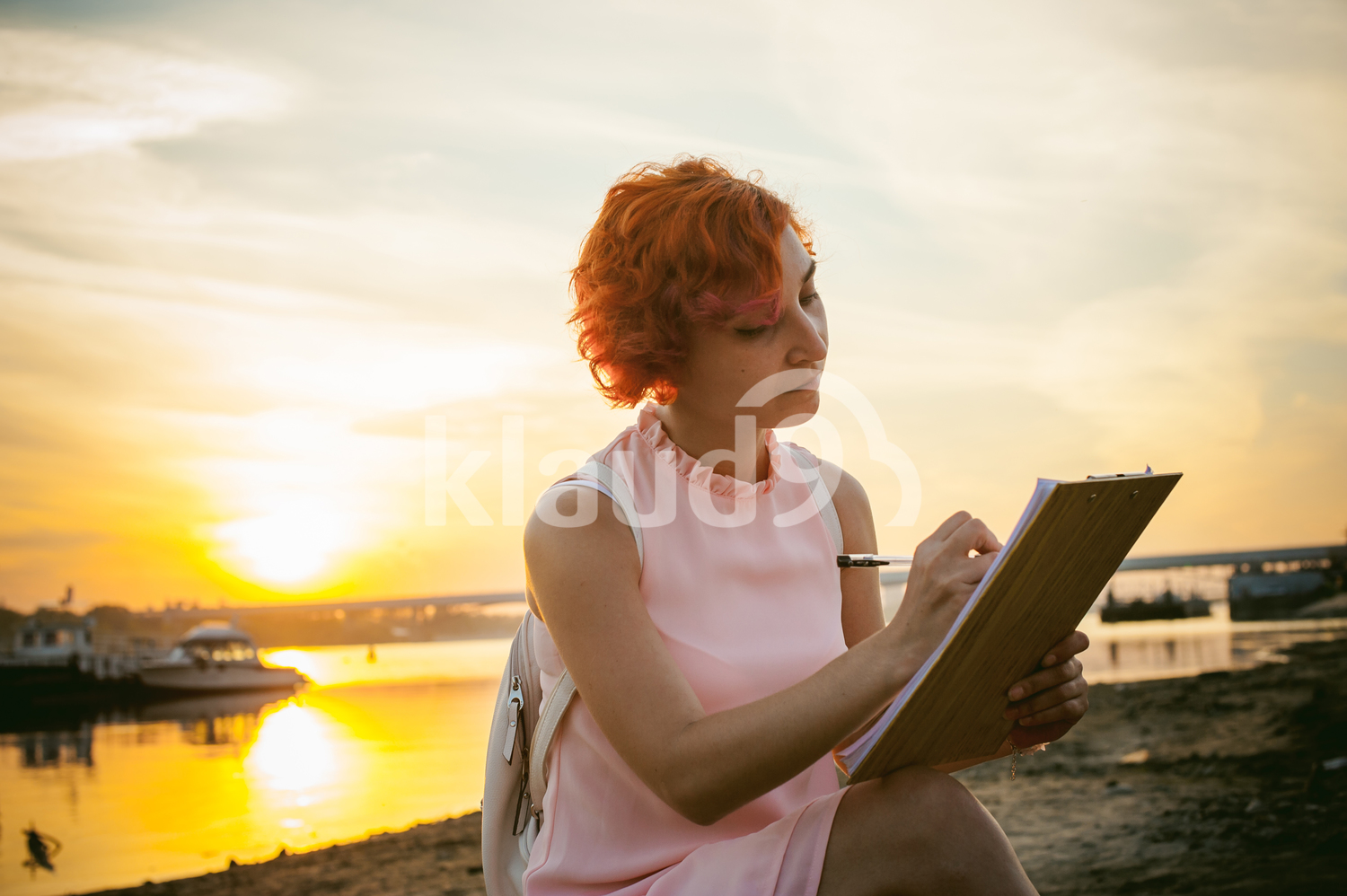 Sunset with a woman signing documents