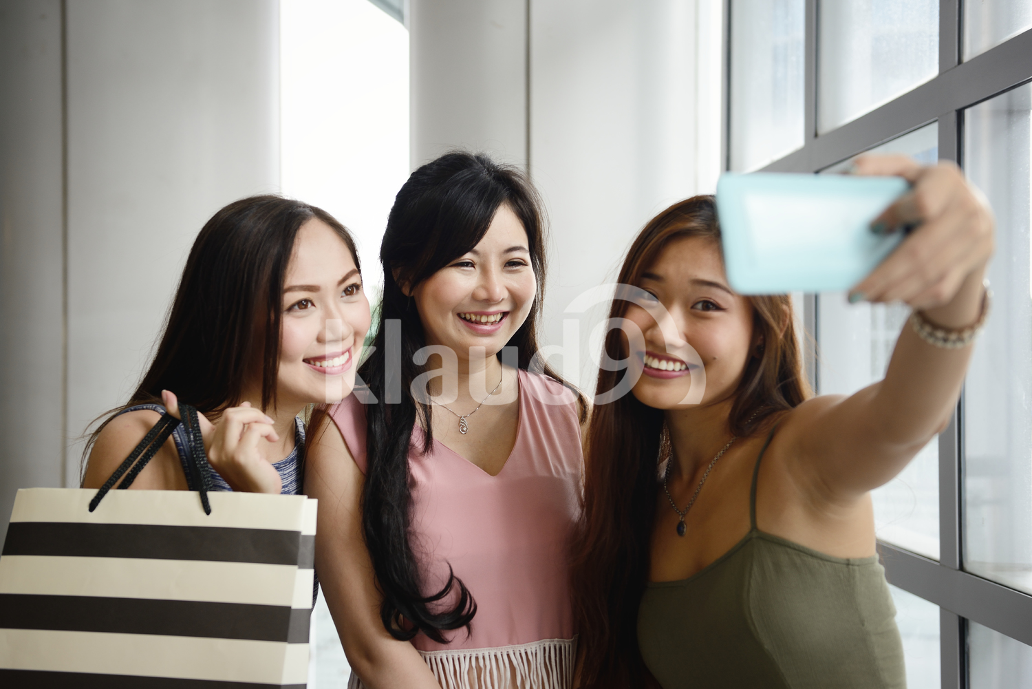 Women with shopping bags taking a selfie