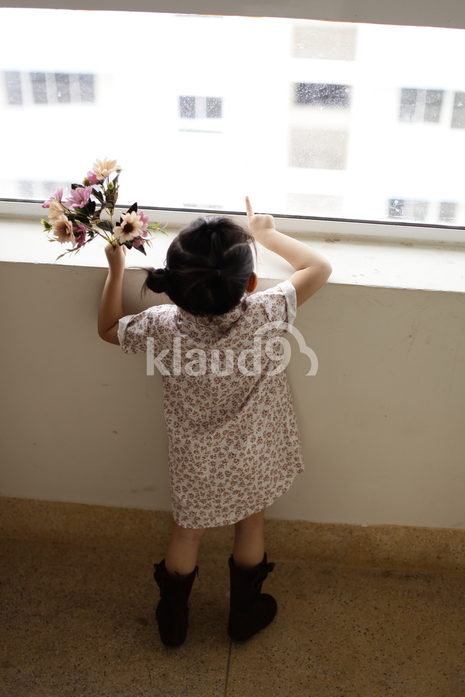 Back view of young girl looking out of the windows