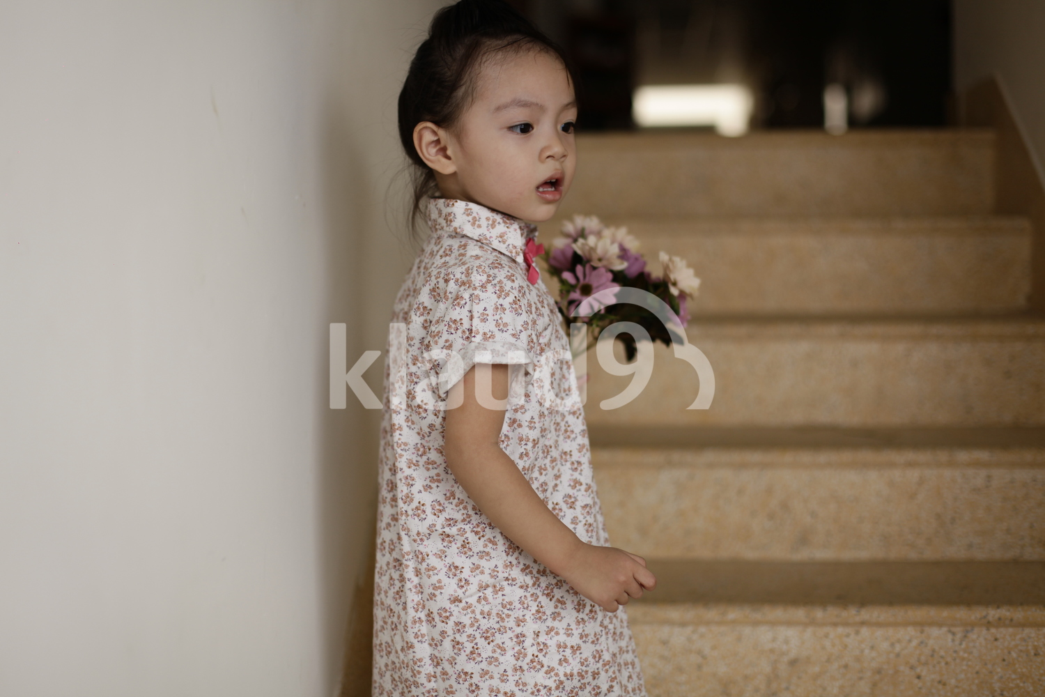 Pretty little girl holding a bunch of colourful flowers in her hands