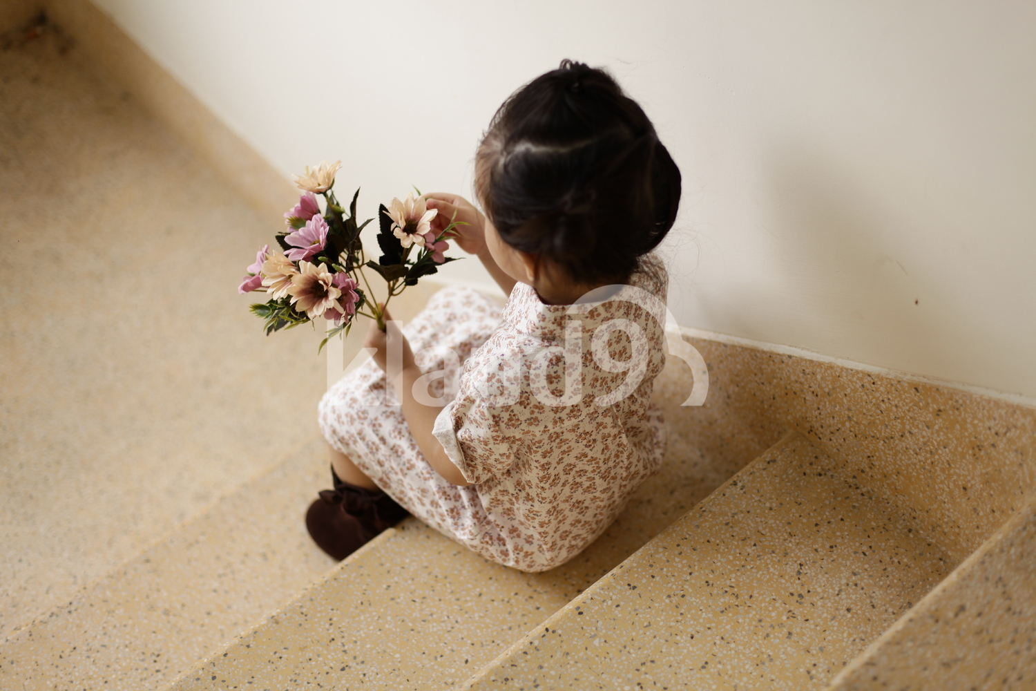 Back view of Vietnamese girl holding flowers