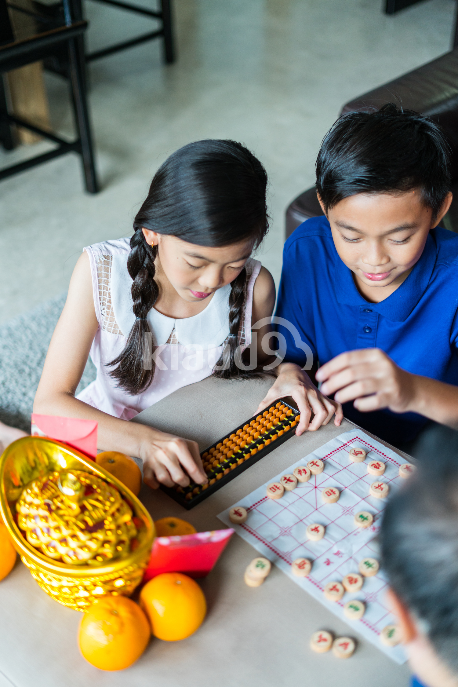 Siblings learning abacus and Chinese Chess
