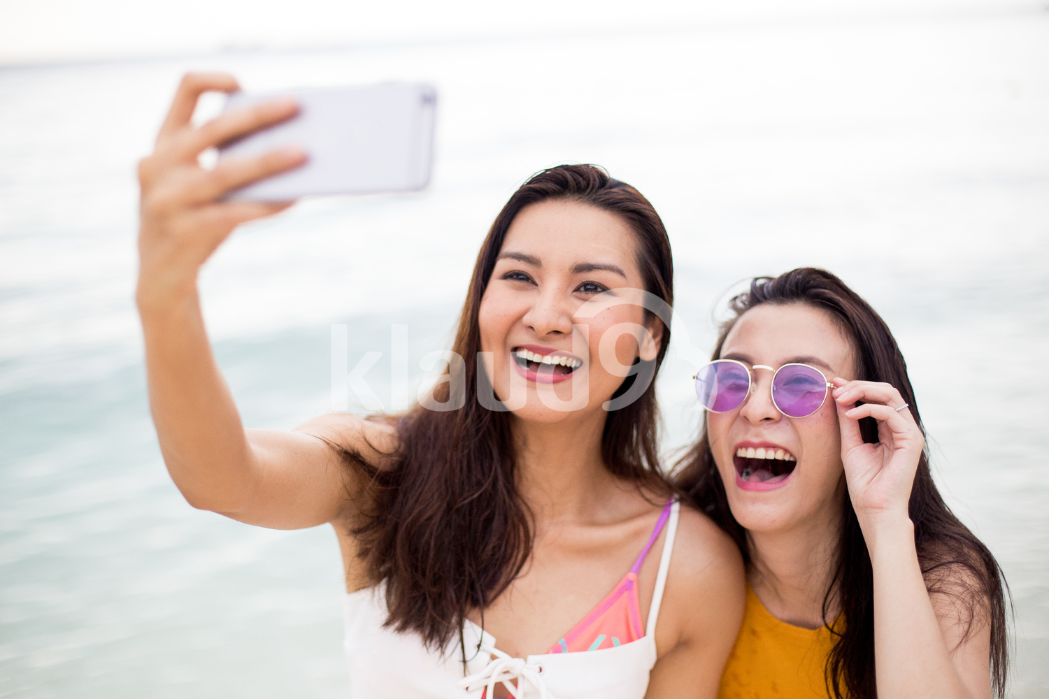 Two friends taking selfie on the beach