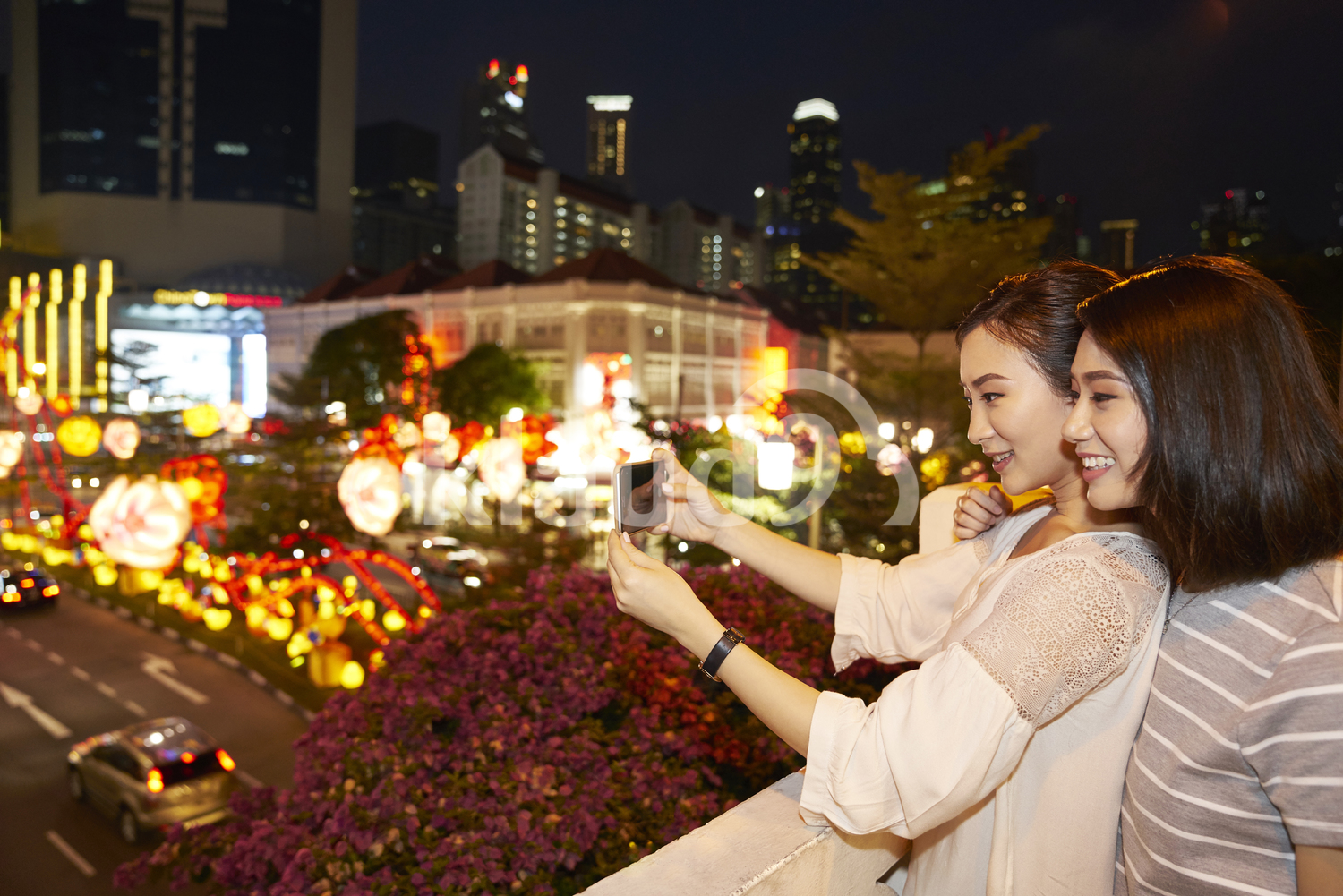 Friends taking a photo of light ups in Chinatown