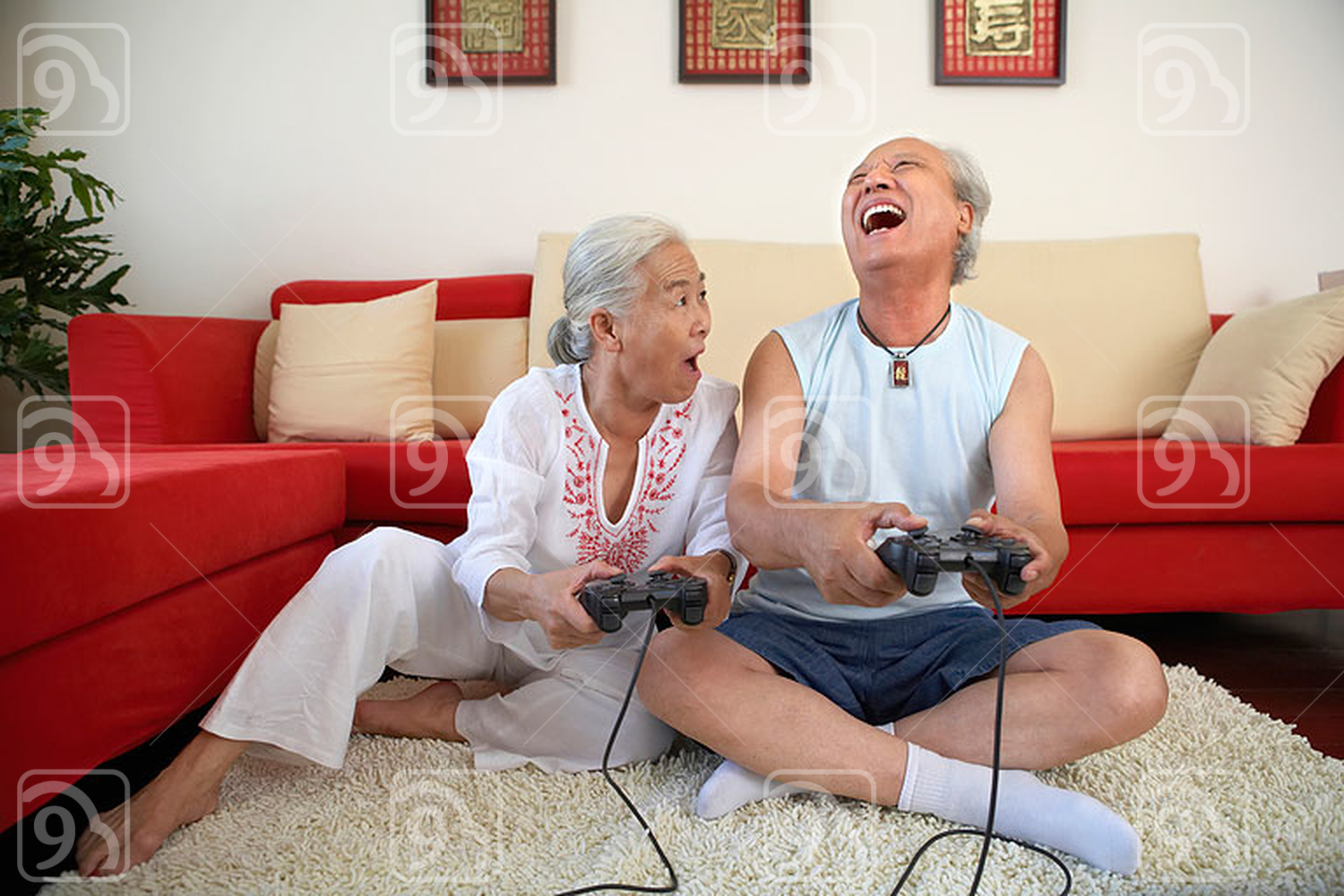 Older Chinese Couple Playing Video Games, Laughing 
