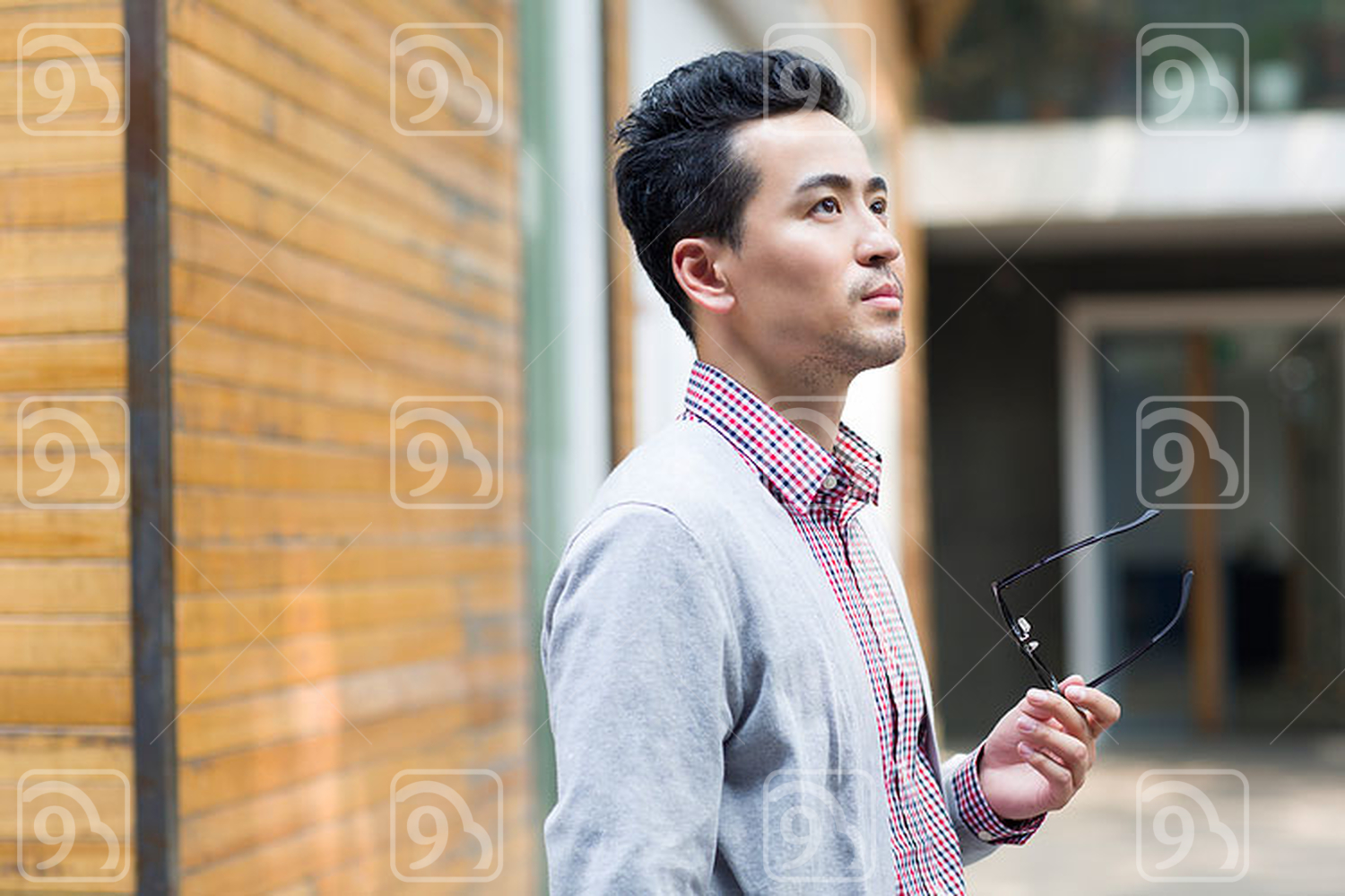Chinese man holding a pair of glasses 