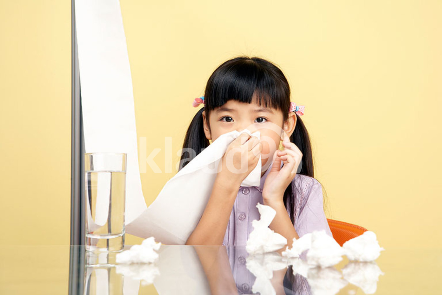 Chinese girl blowing her nose on tissues