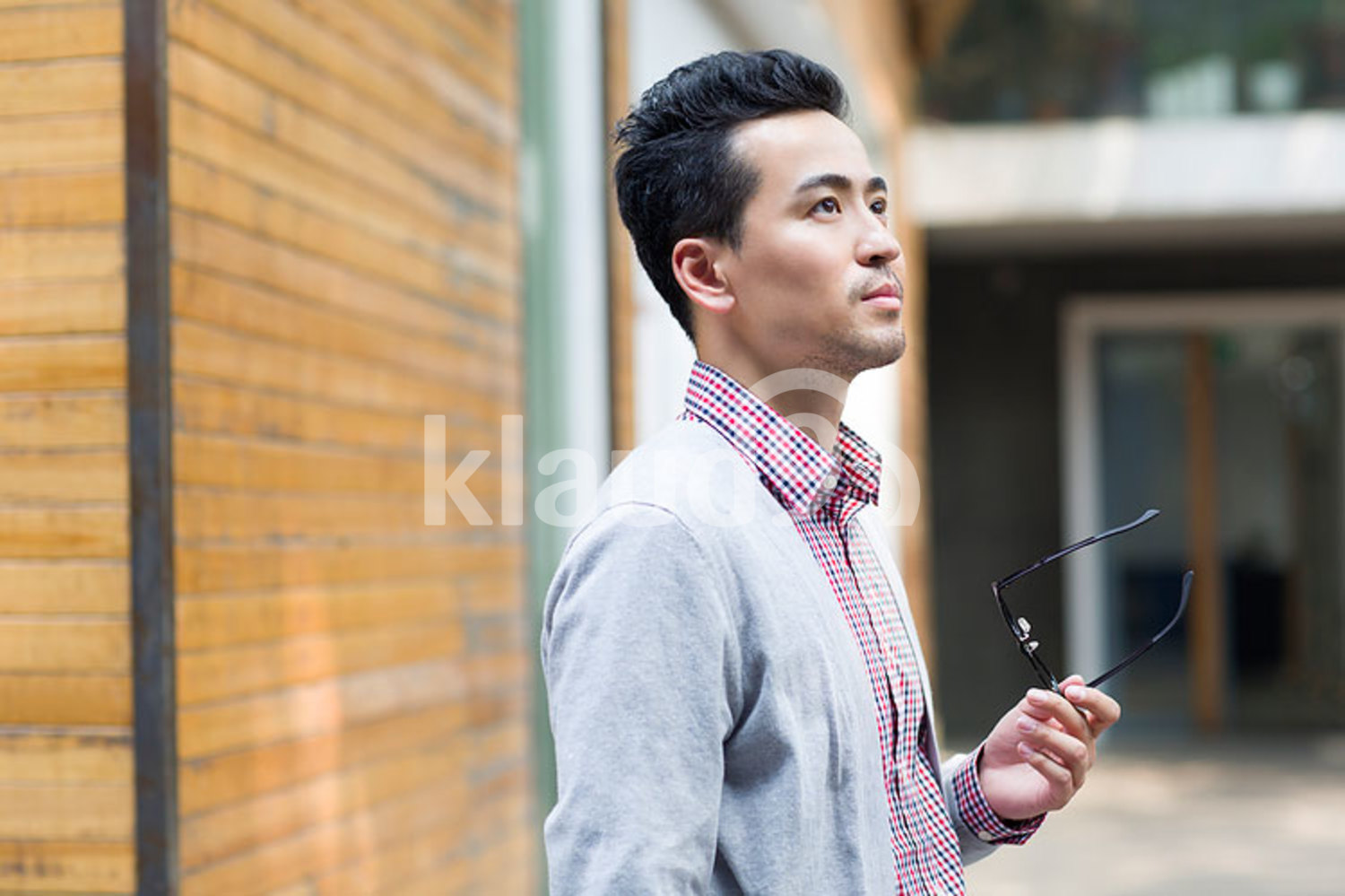 Chinese man holding a pair of glasses
