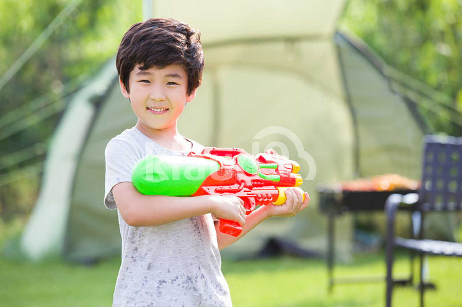 Happy Chinese boy holding a squirt gun