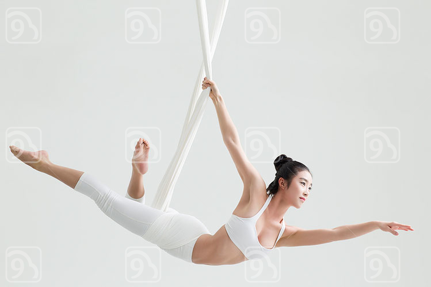Young Chinese woman practicing aerial yoga 
