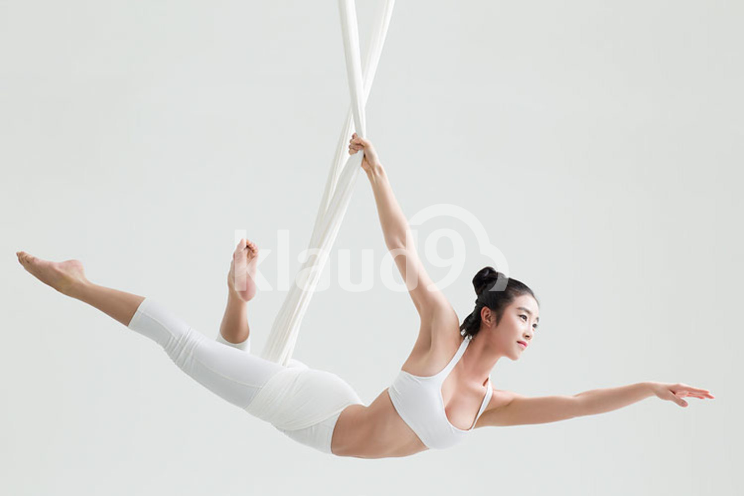 Young Chinese woman practicing aerial yoga