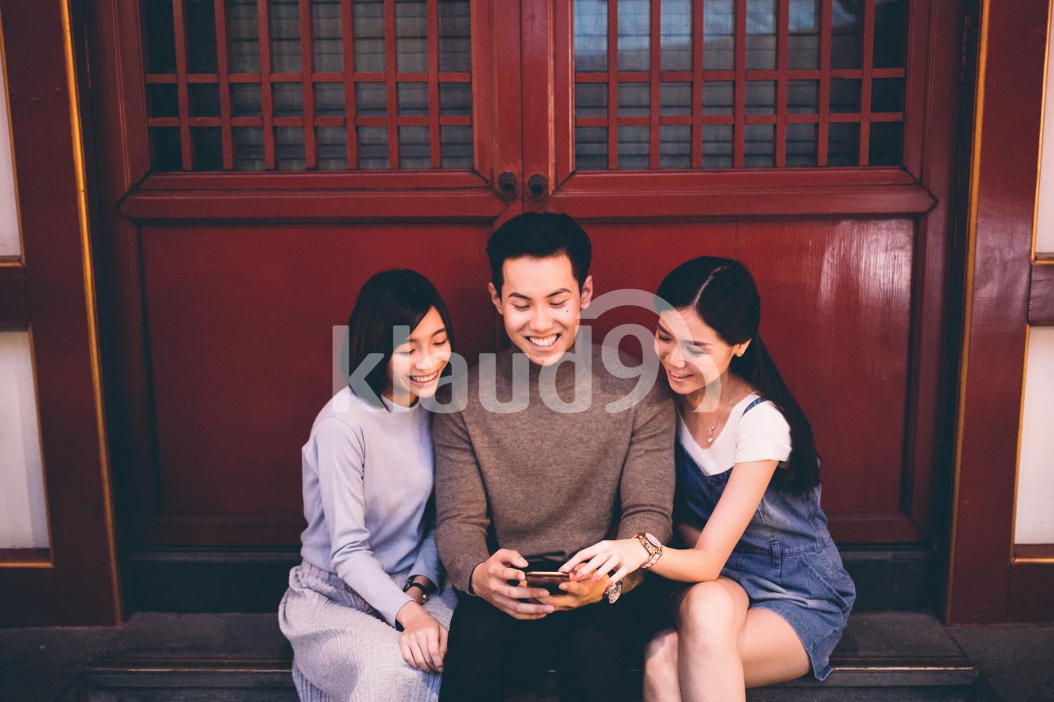 Beautiful young friends checking out their selfies in a cellphone