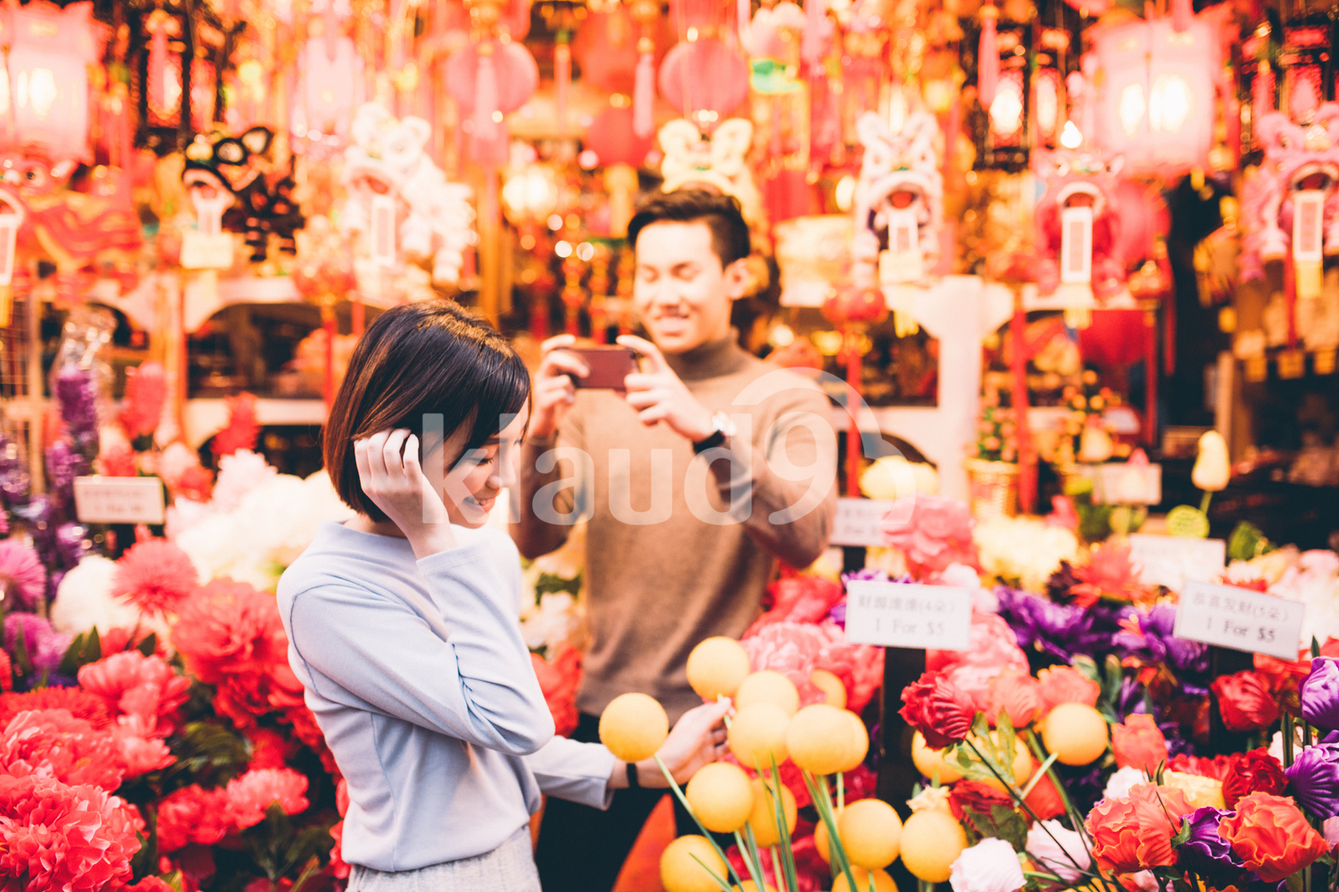 Man taking a photo of his girlfriend shopping in Chinatown, Singapore