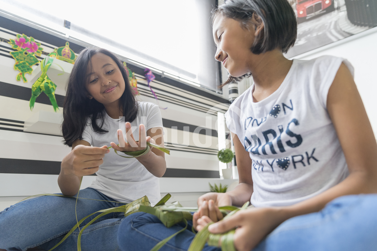 Adorable siblings preparing Ketupats for Hari Raya