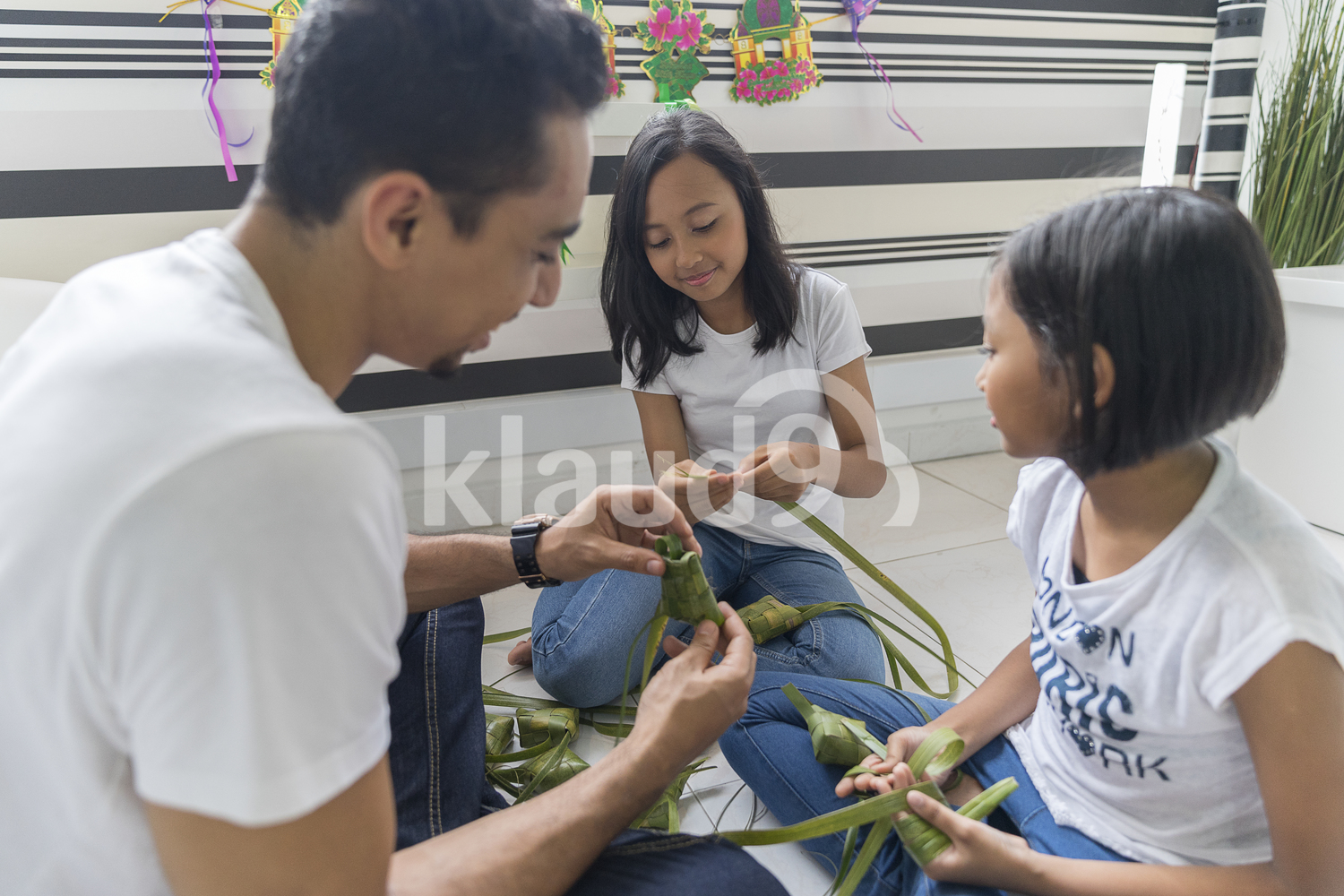 Family making ketupat together during Hari Raya