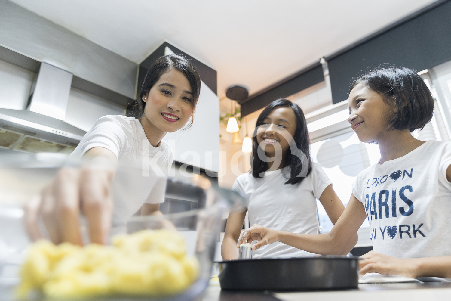 Mother teaching her kids to bake
