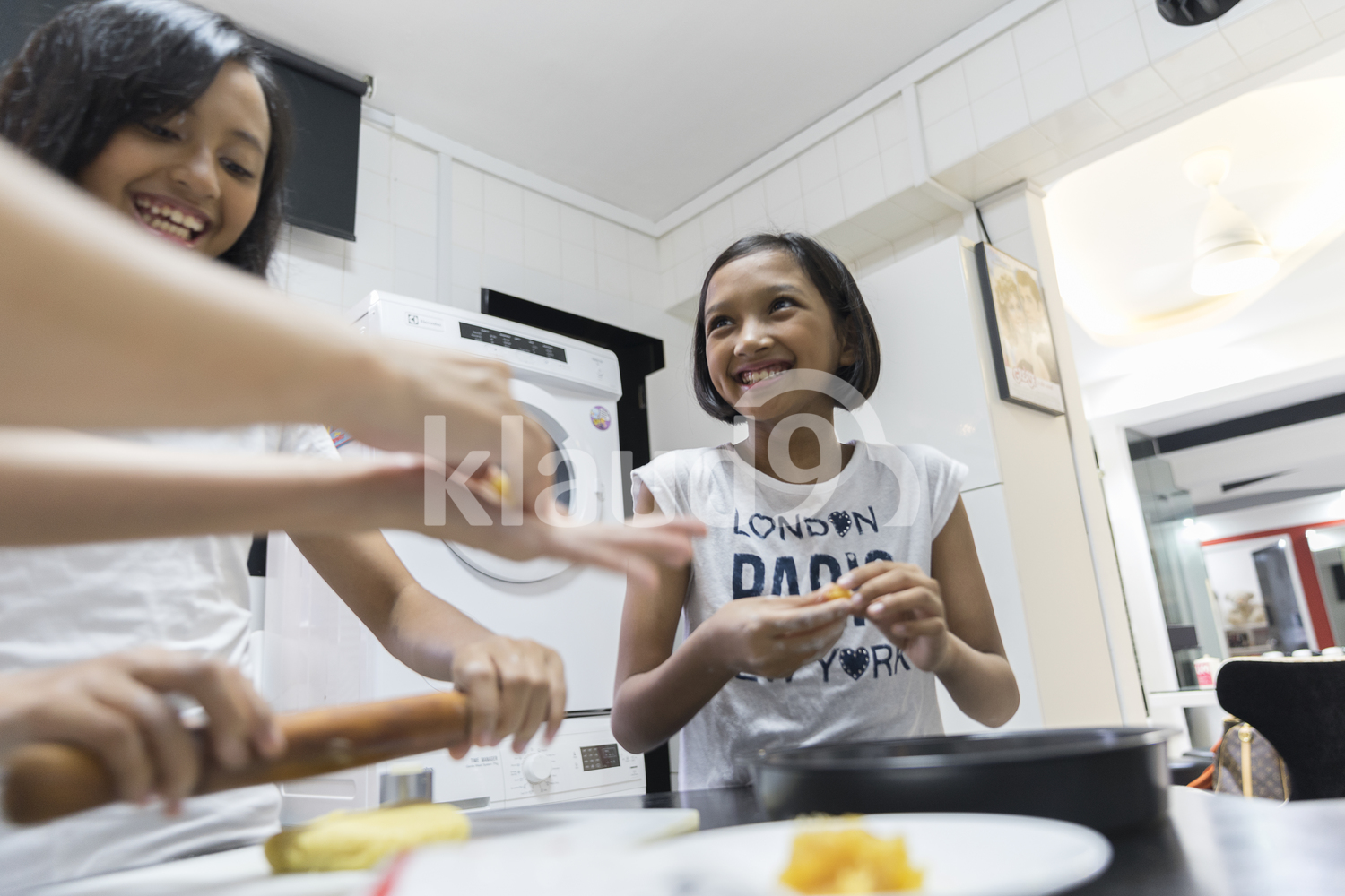 Young girls having fun baking goodies for Hari Raya