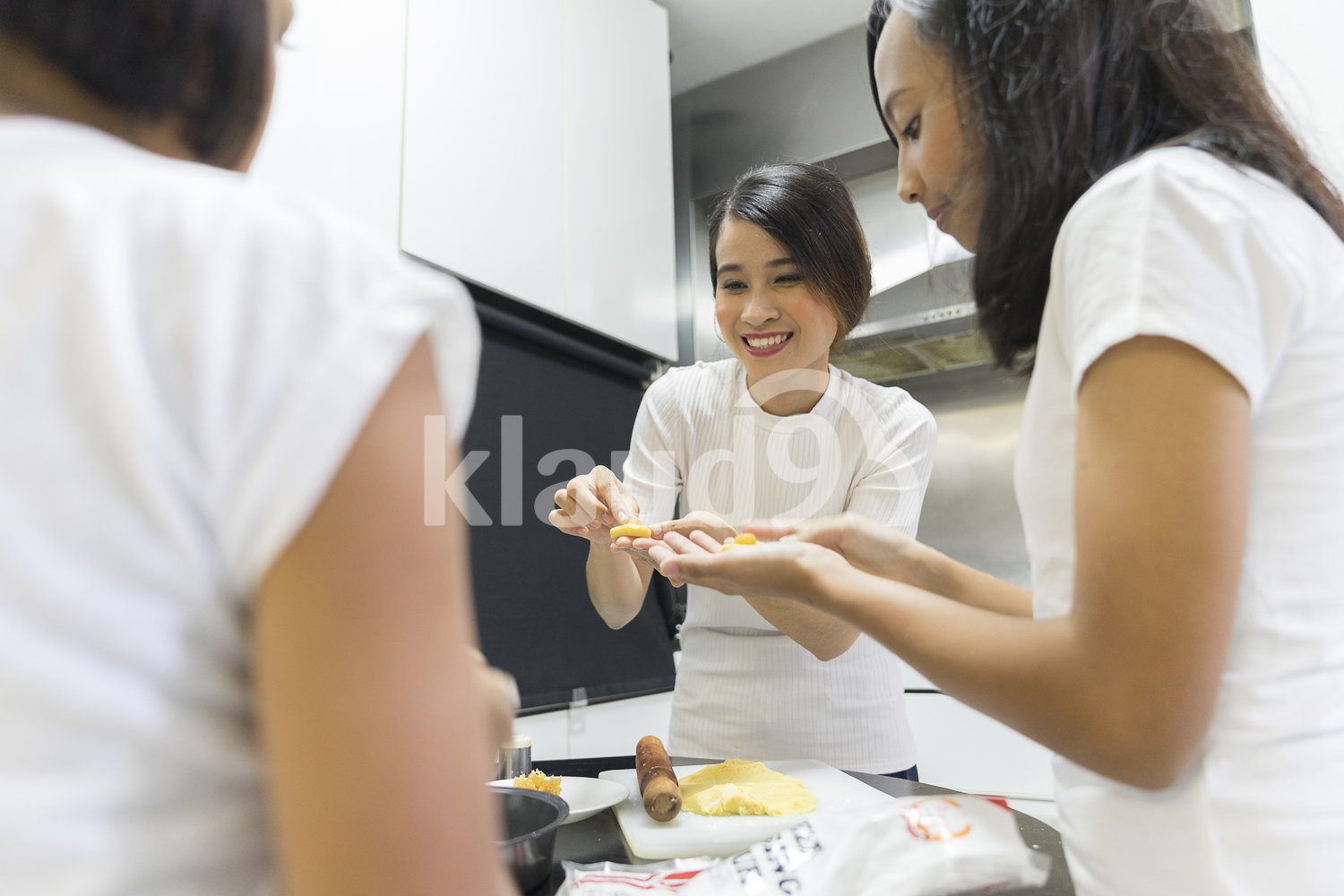 Mother teaching her daughters baking skills