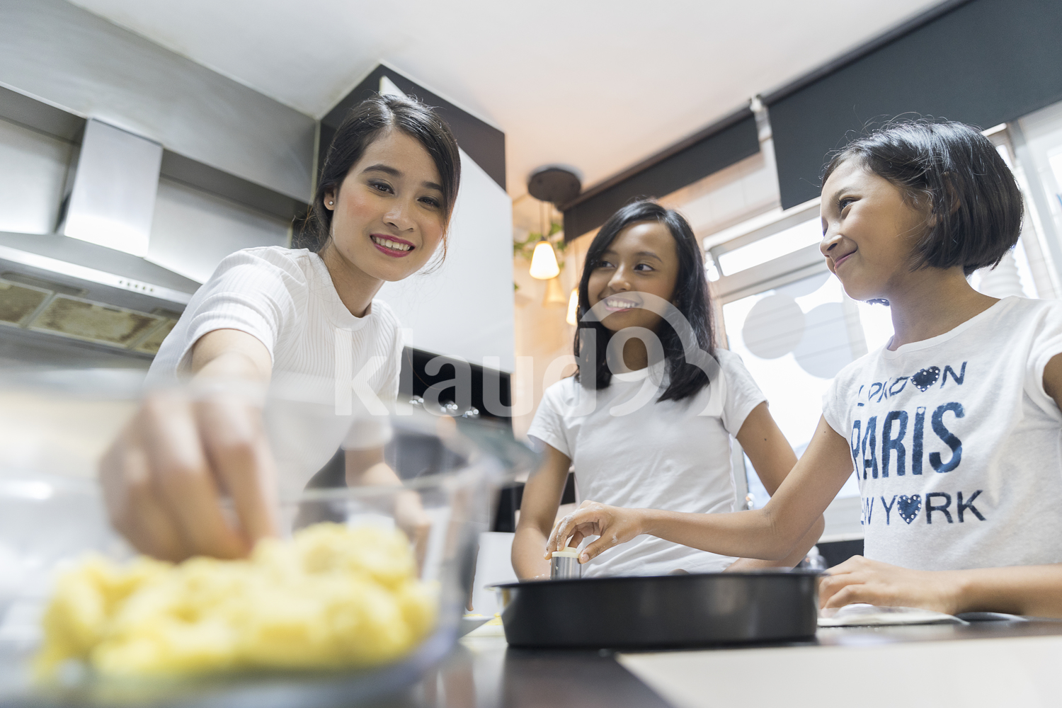 Mother teaching her kids to bake goodies for Hari Raya