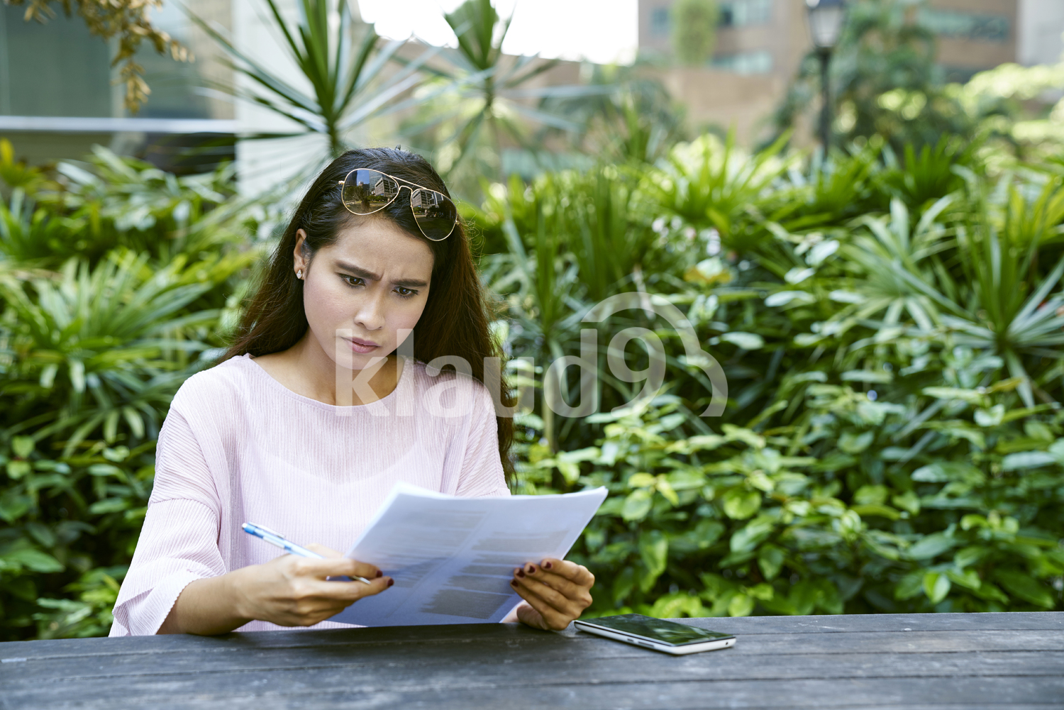 Young Malay lady frustrated at the documents she is looking at