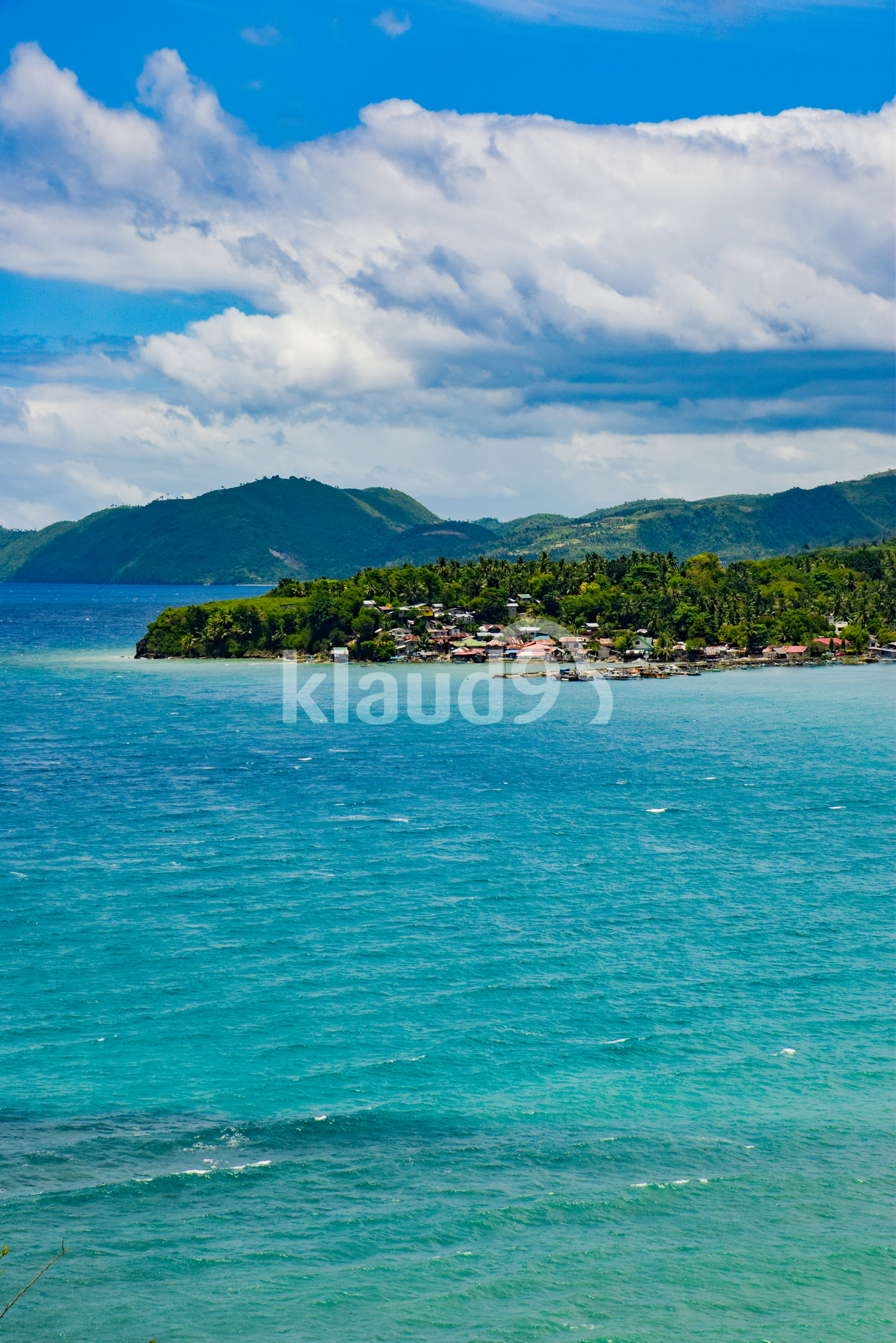 Island surrounded by blue waters and skies