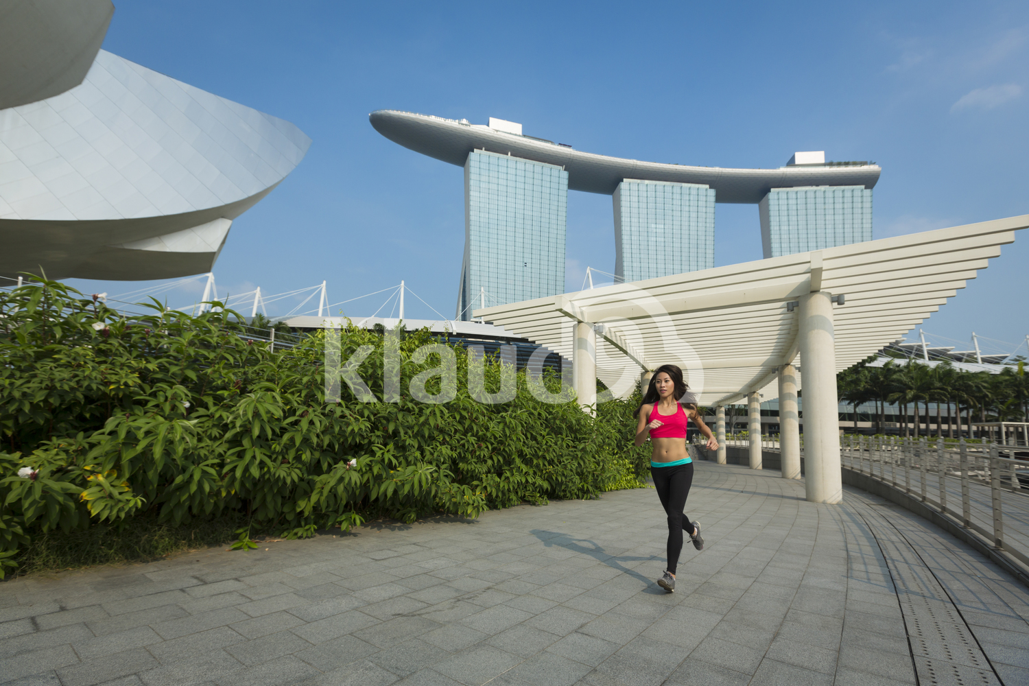 Young sian woman jogging around Marina Bay Sands, Singapore