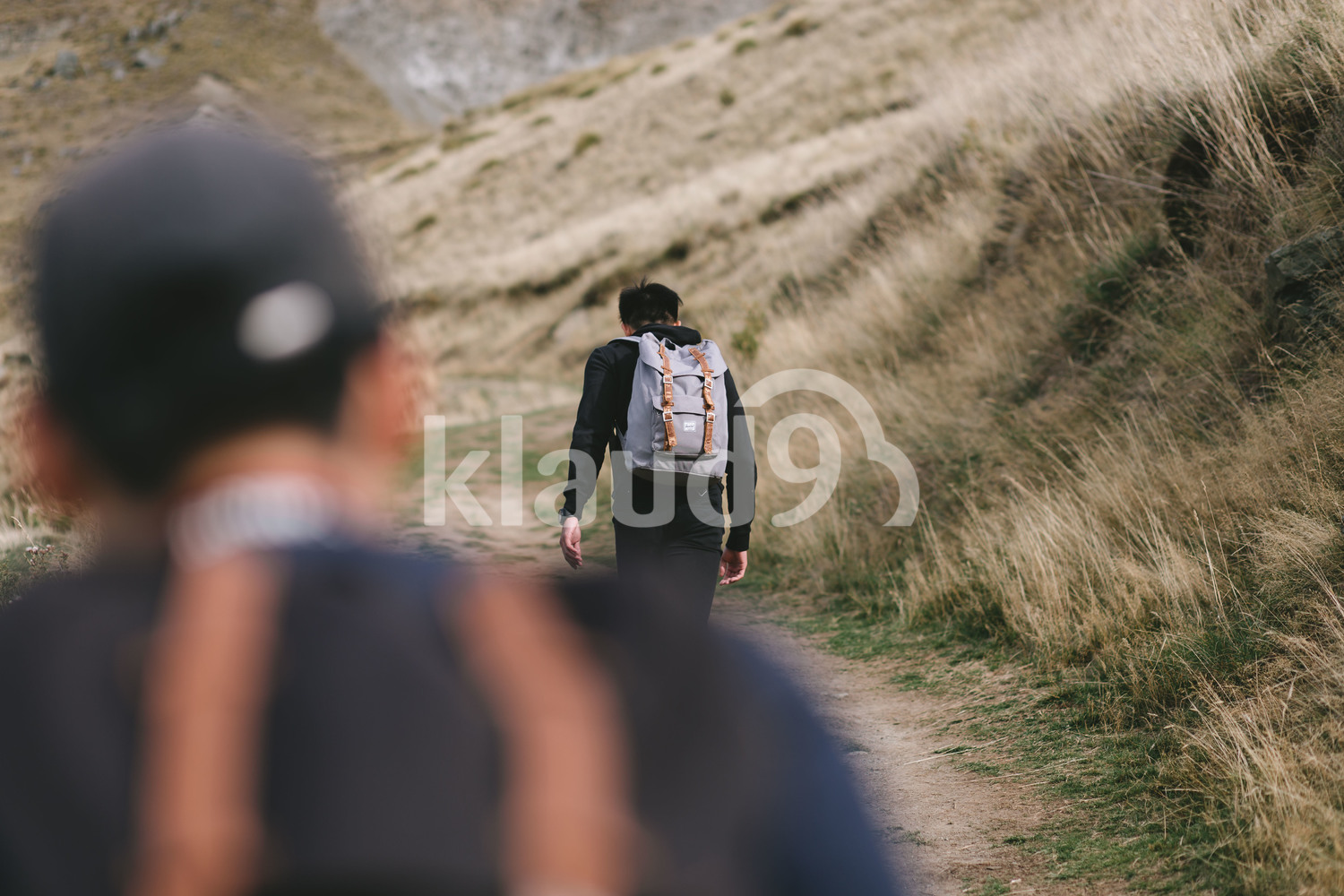 Young man trudging up Mountain Cook National Park, New Zealand