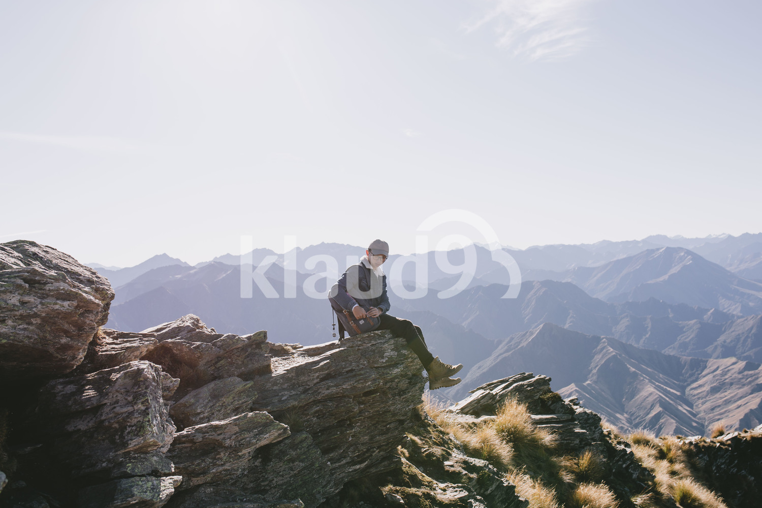 Young man reaching for bag pack at Mountain Cook National Park, New Zealand