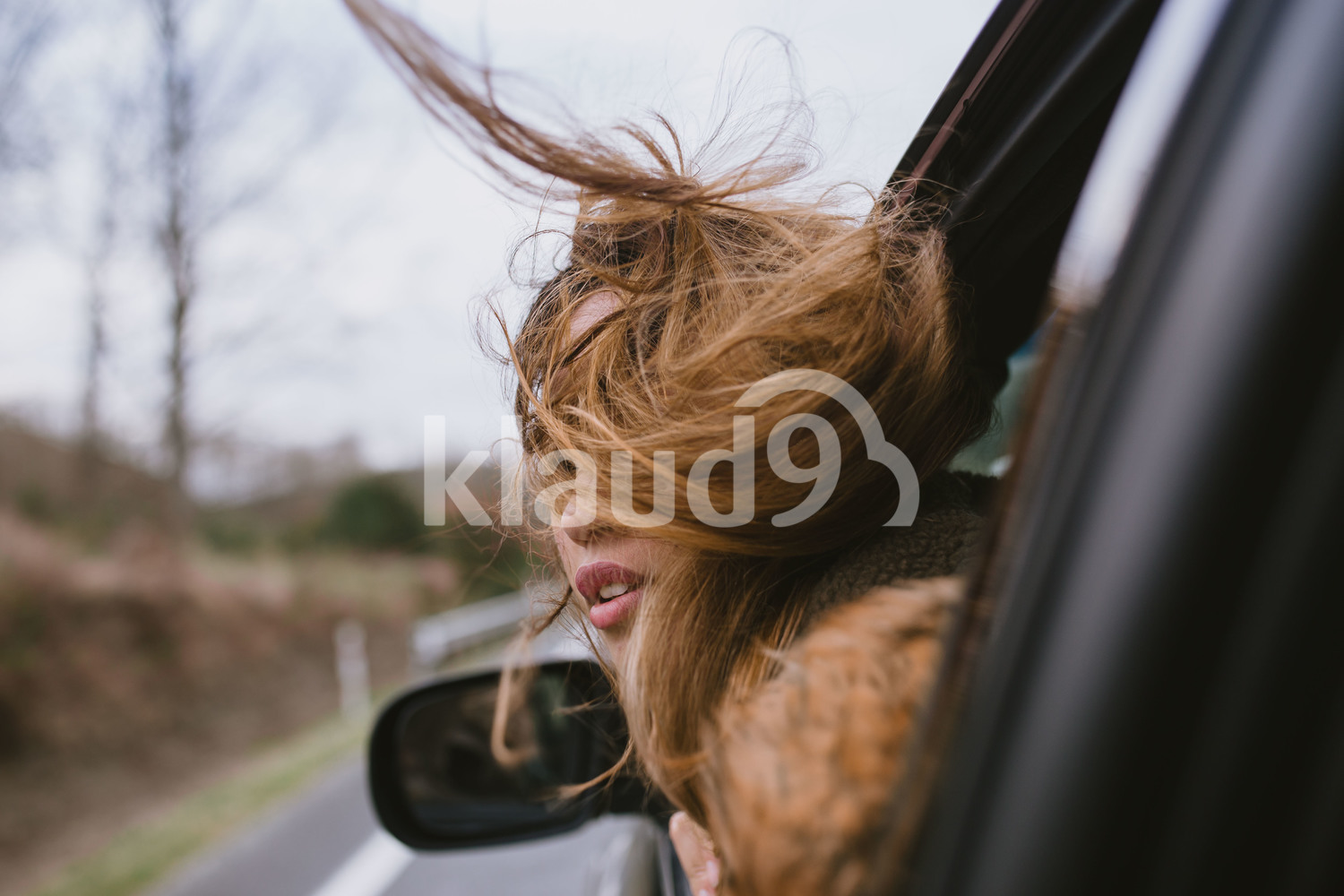 Young woman peering out the window as the car travels through the beautiful landscape of New Zealand