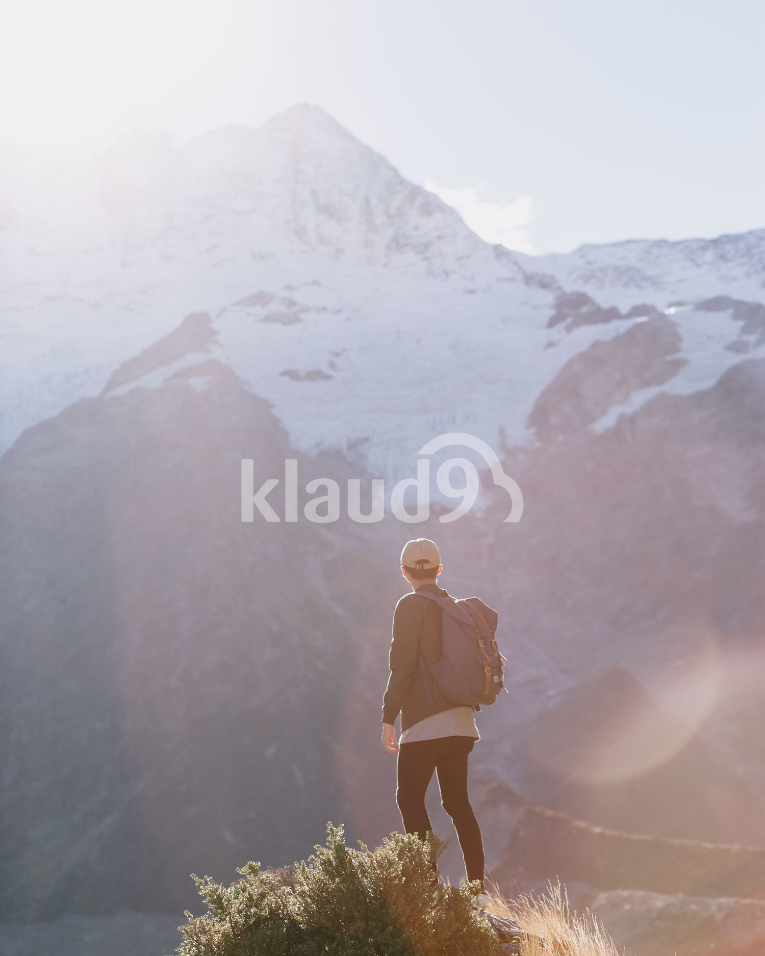 Back view of a young man trekking through Mountain Cook National Park in New Zealand