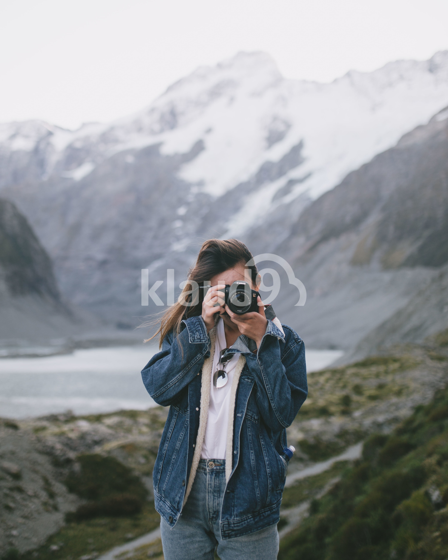 Young female photographer taking in the sights at Milford Sound, New Zealand