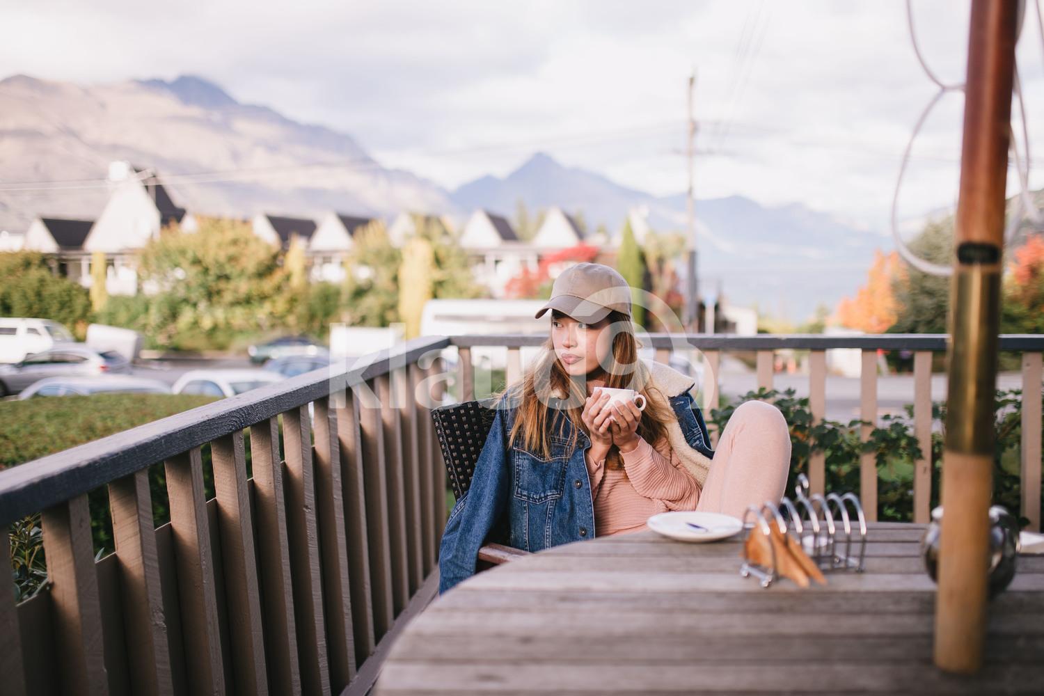 Young hipster woman chilling by the balcony at home in Queenstown, New Zealand
