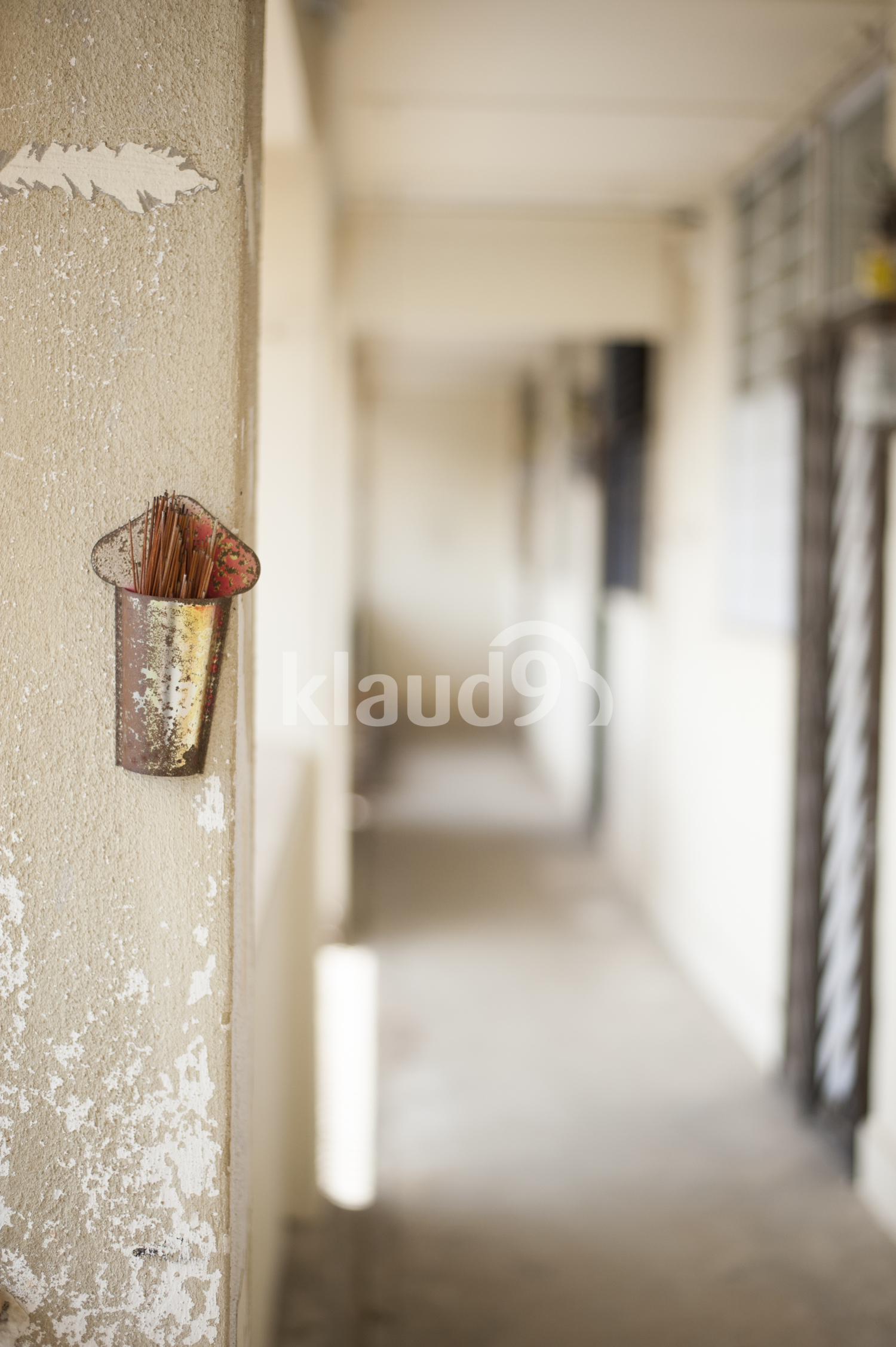 Weathered incense holder along a empty corridor.