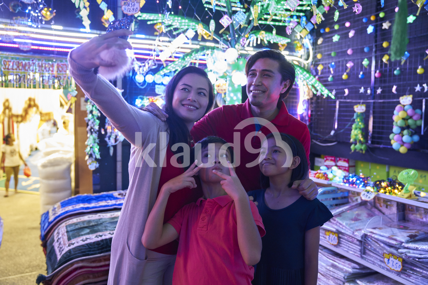 Young family taking selfies at Hari Raya Geylang Bazaar, Singapore