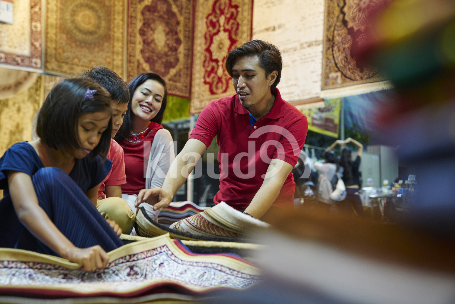 Young family browsing for carpets at Geylang Bazaar, Singapore