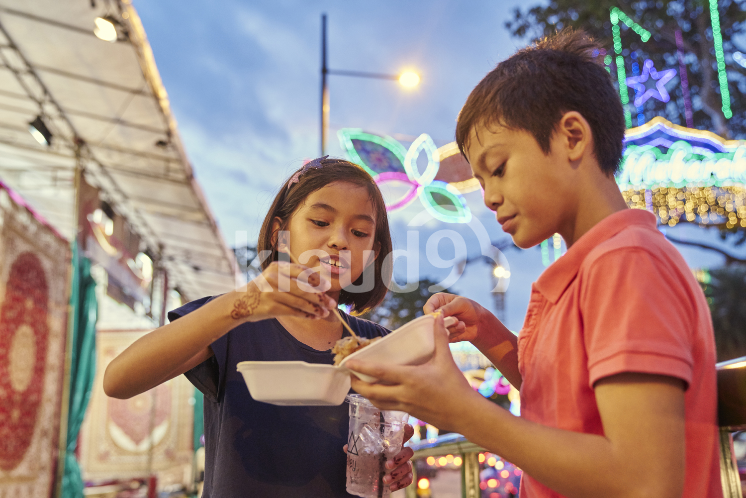 Siblings breaking fast at Hari Raya bazaar, Singapore