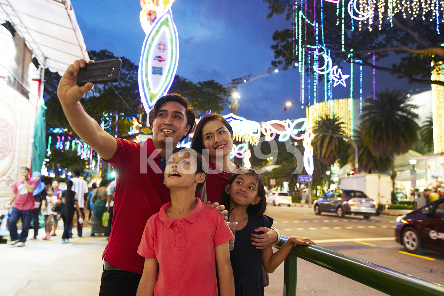 Happy family taking selfies at Hari Raya Geylang Bazaar, Singapore