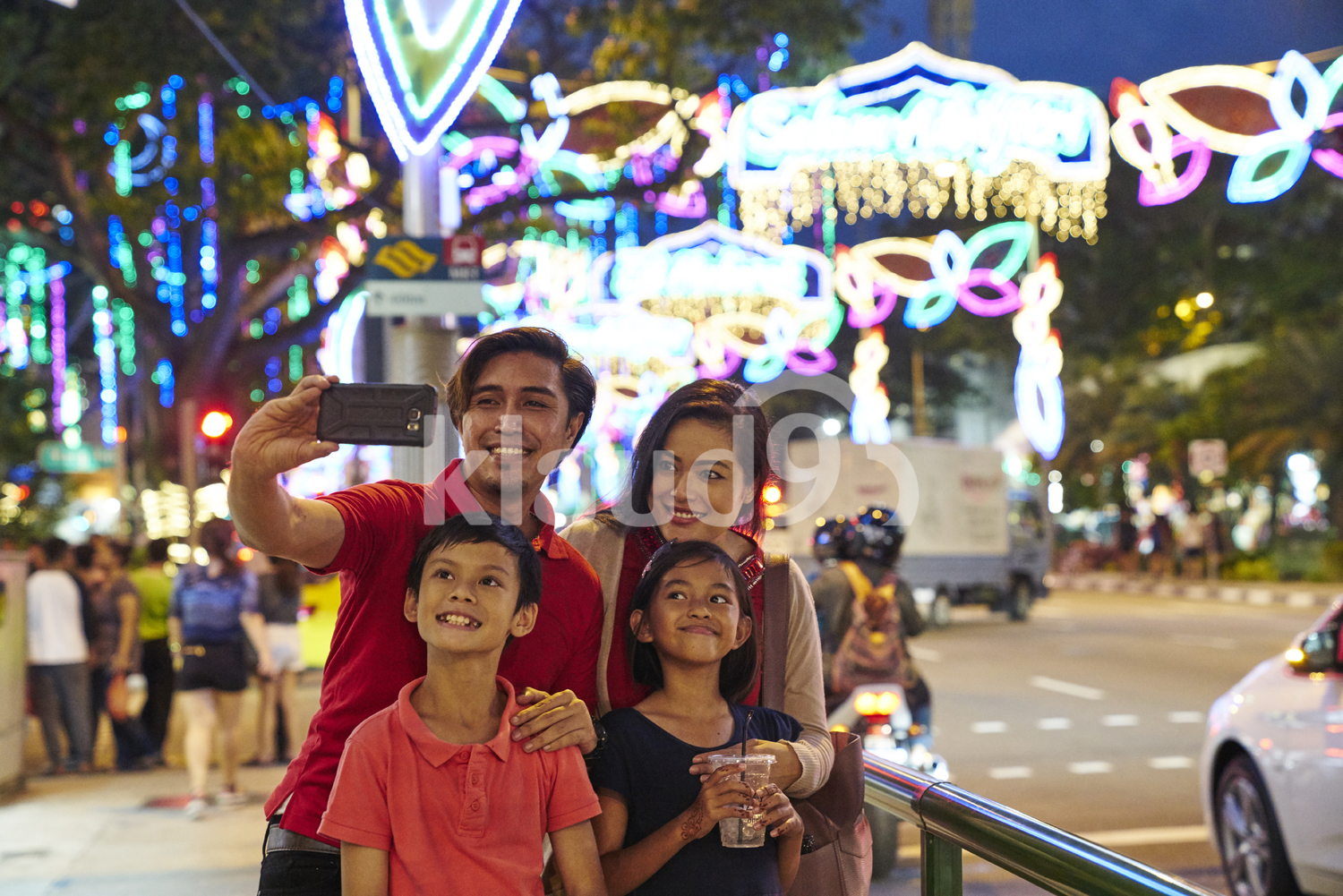 Cheerful family taking selfies at Hari Raya Geylang Bazaar, Singapore