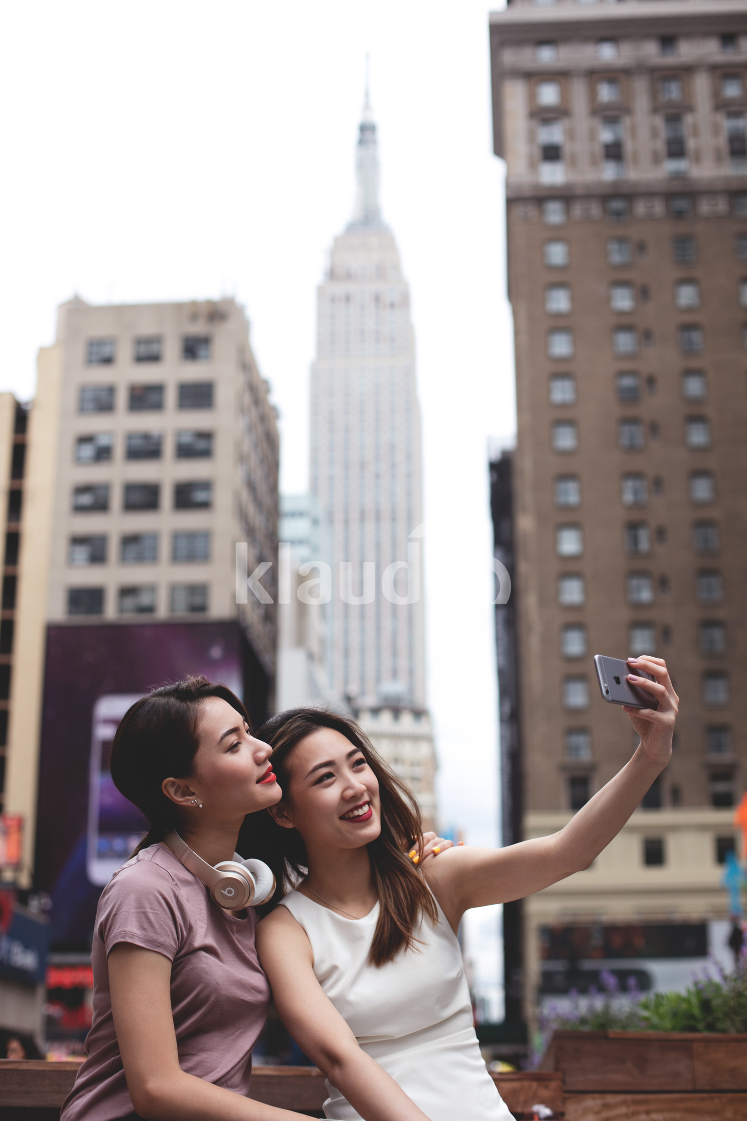 Women taking a selfie with Empire state build in the background. 